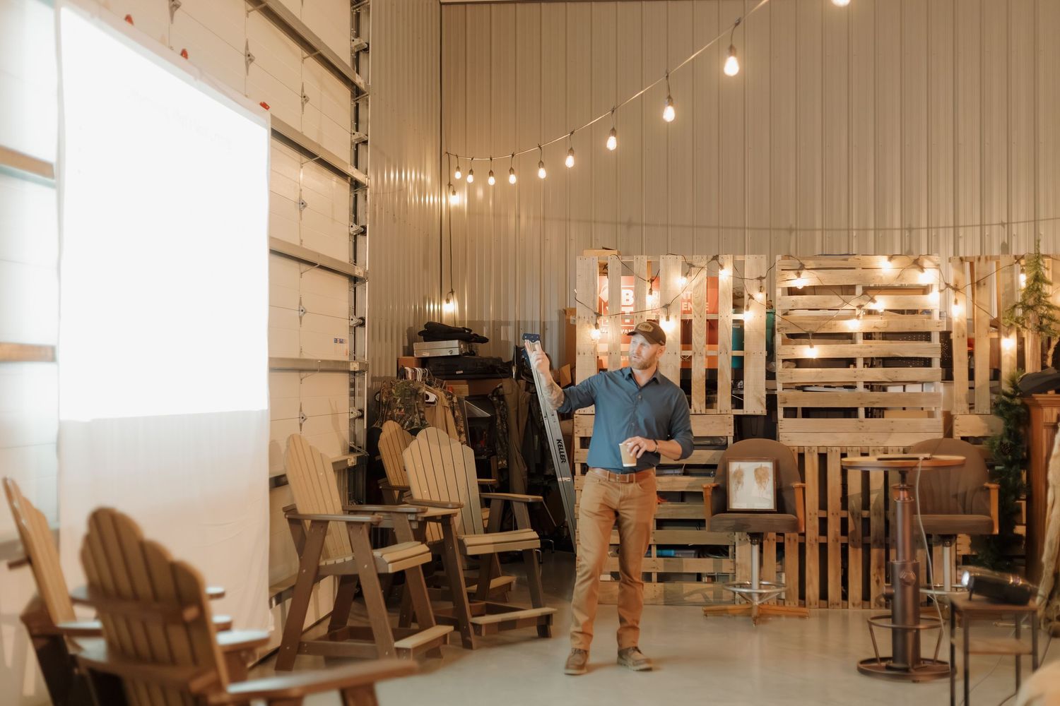 String lights illuminate a modern event space with white walls and wooden accents.