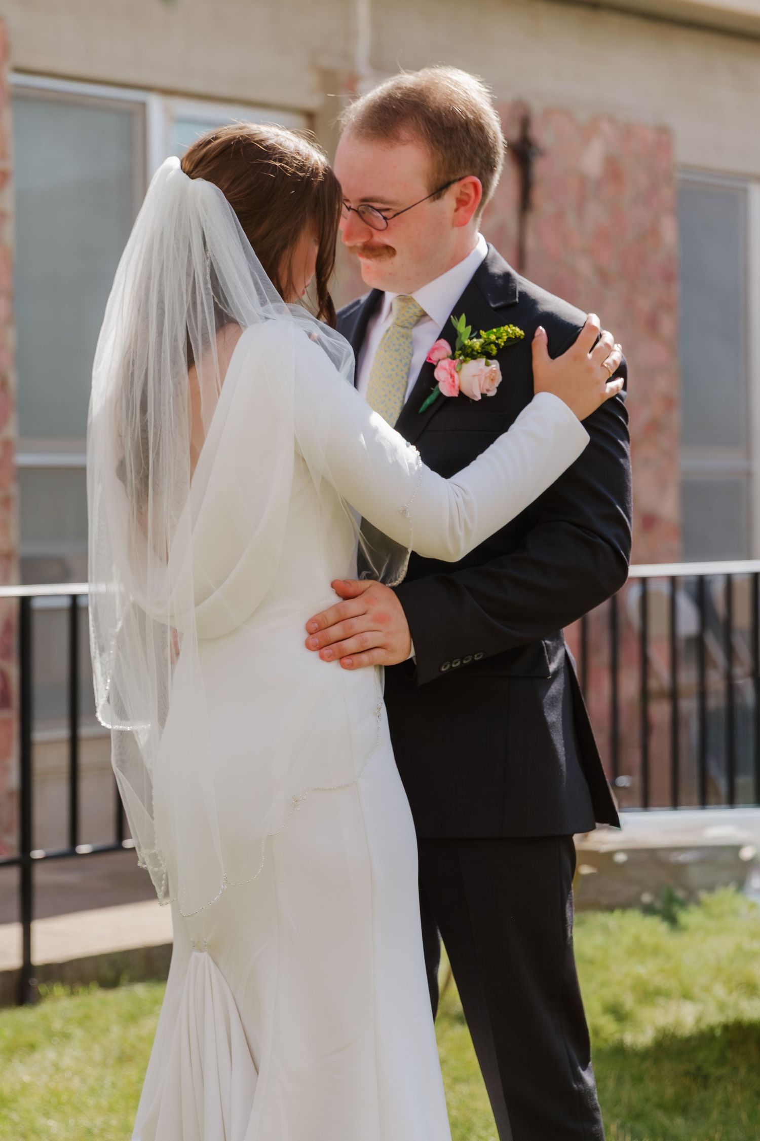 A couple shares their first dance outdoors on a sunny day.