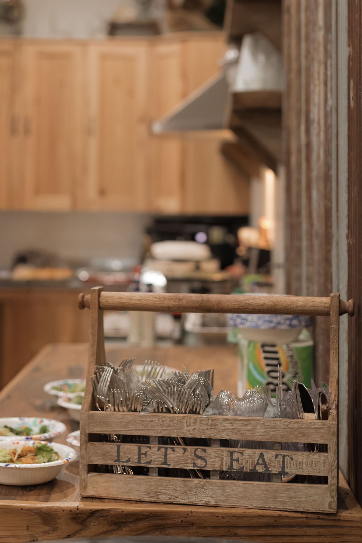 Rustic wooden crate with 'Let's Eat' text displayed in dining setting.