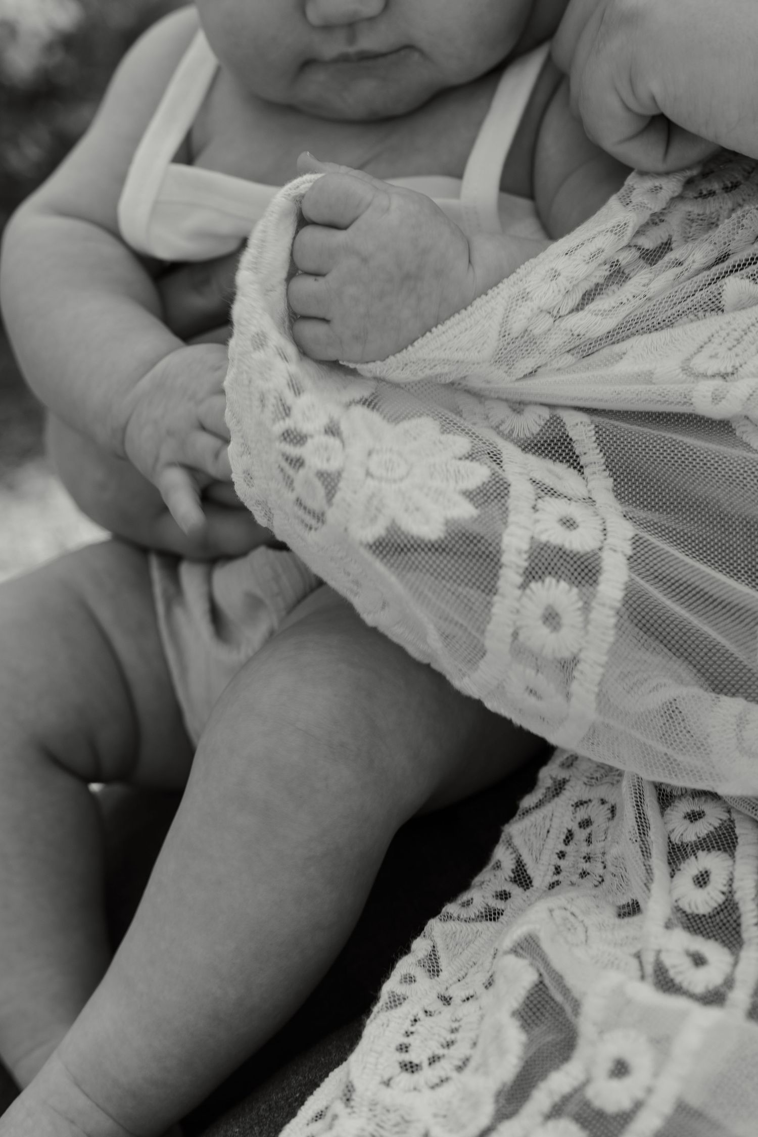 Close-up detail of delicate white lace fabric with floral patterns.
