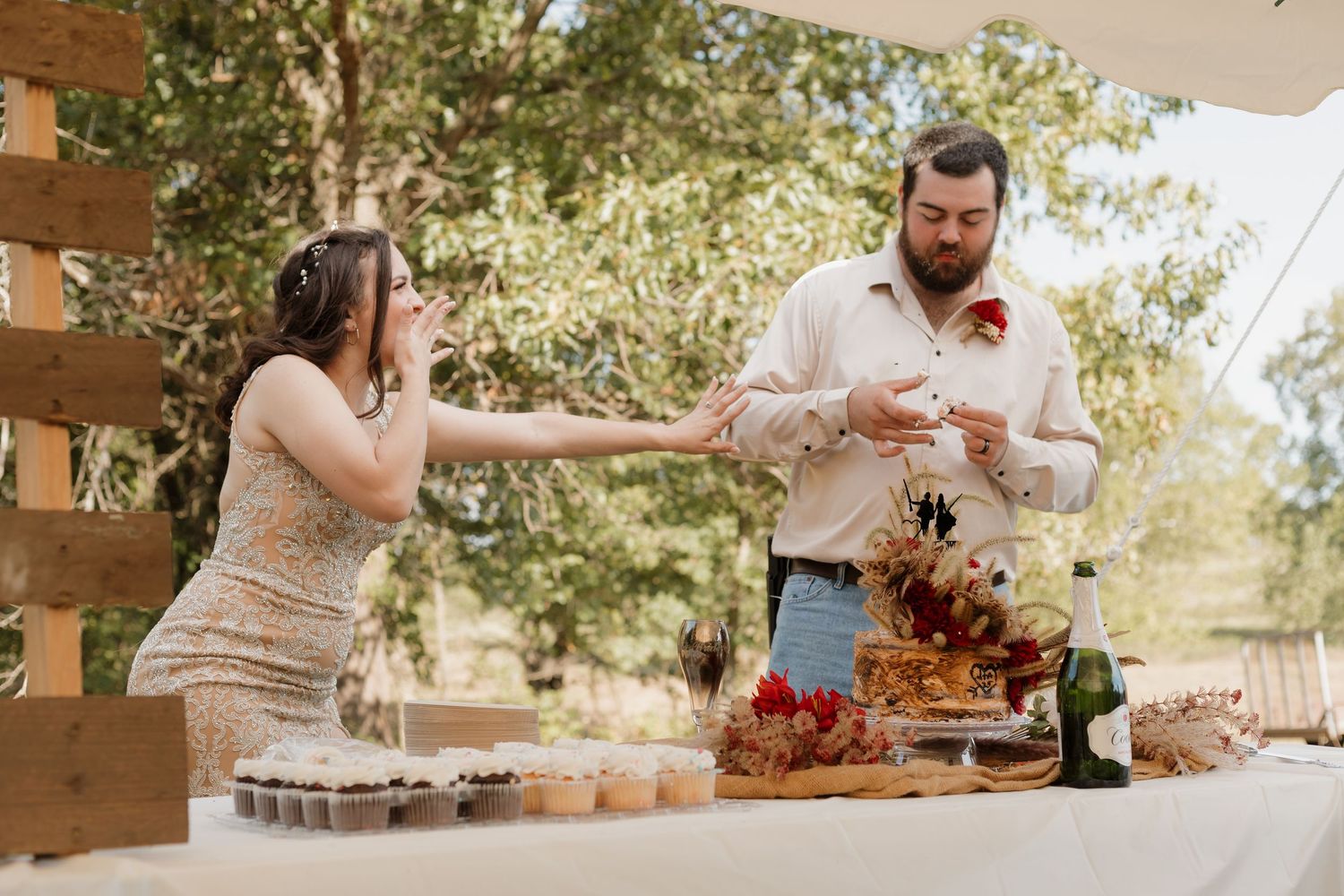 Wedding reception buffet table with desserts and treats being served outdoors.