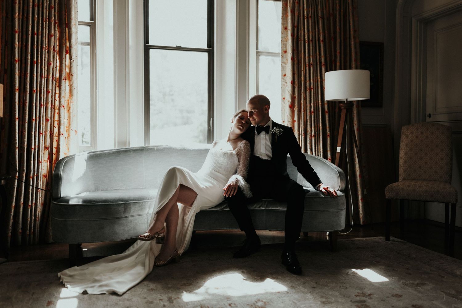 Dramatic window light illuminates a room with flowing curtains and elegant furniture.