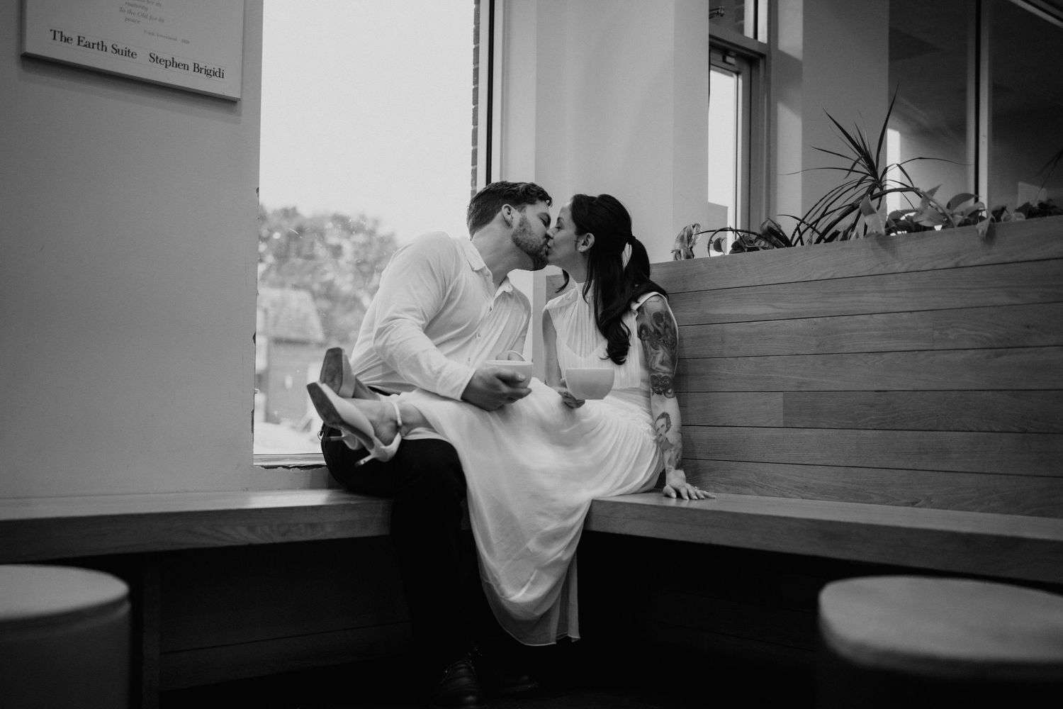 Black and white photo of intimate moment in indoor setting.