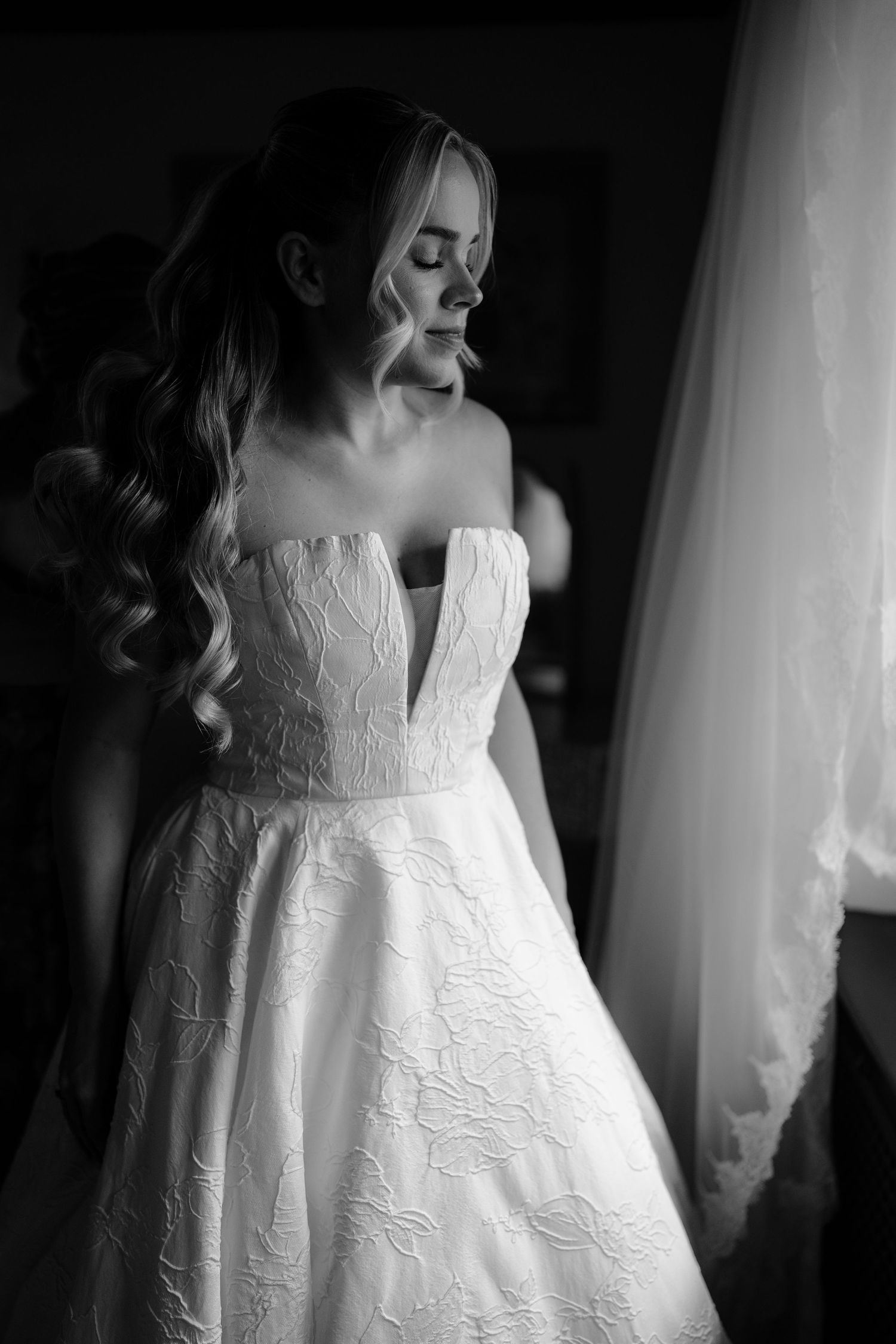 Close-up details of an elegant white lace wedding dress with intricate embroidery patterns.