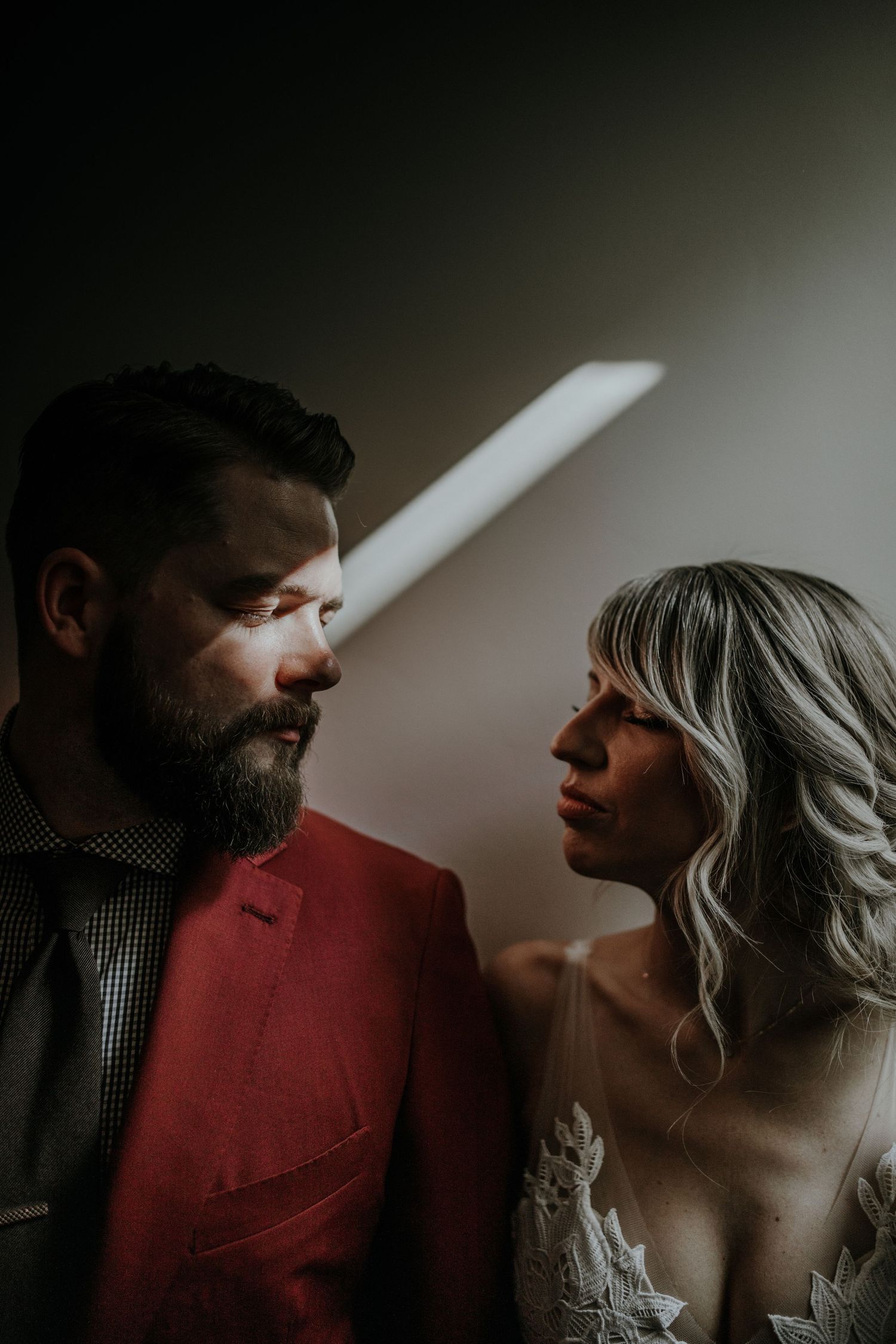 Dramatic moody portraits with strong shadows and intimate poses.