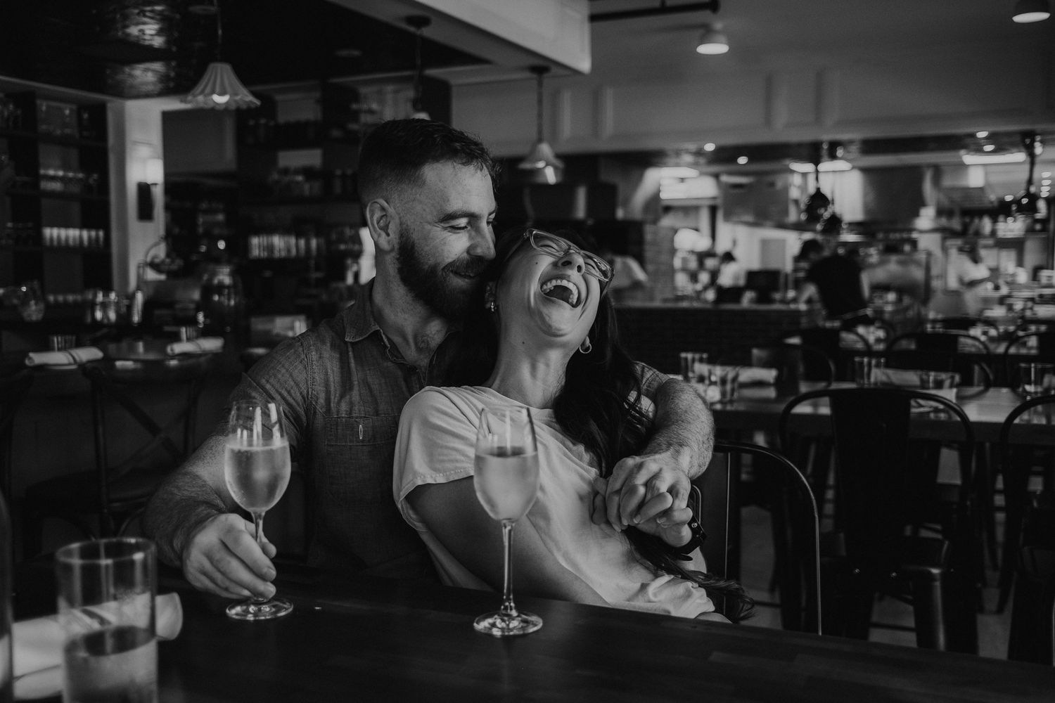 Dimly lit bar interior with guests enjoying drinks and conversation.
