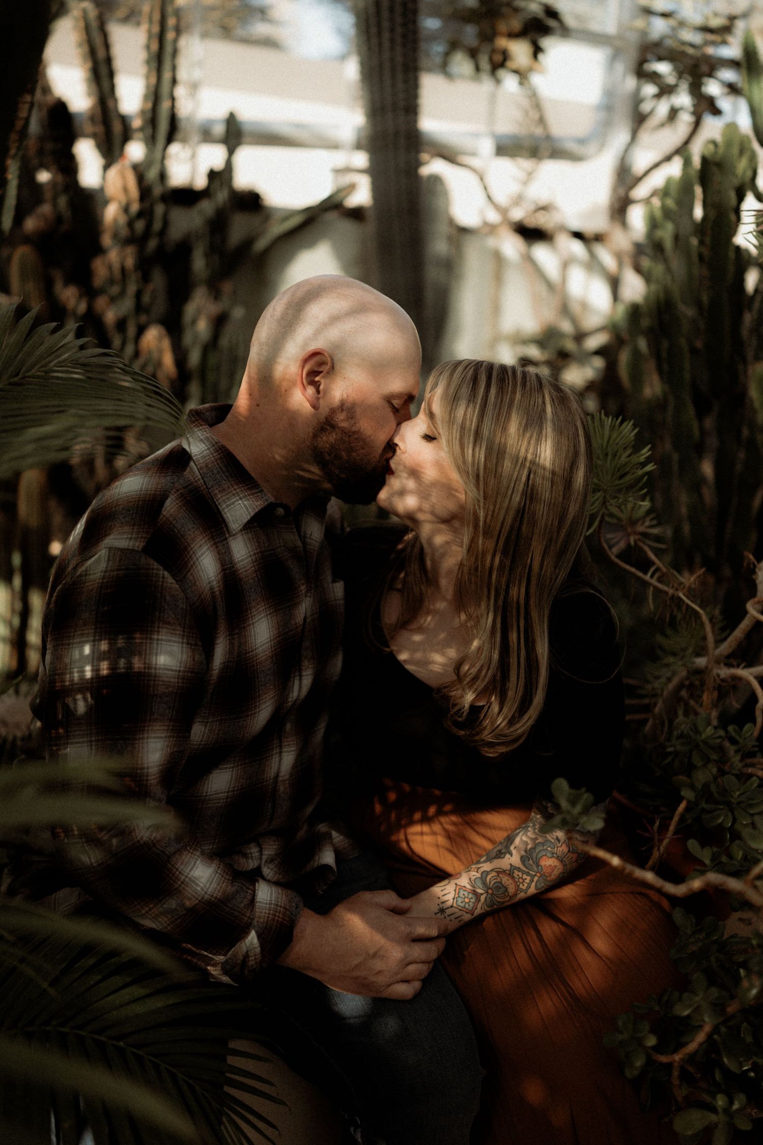 An intimate greenhouse photoshoot among tropical plants and filtered sunlight.