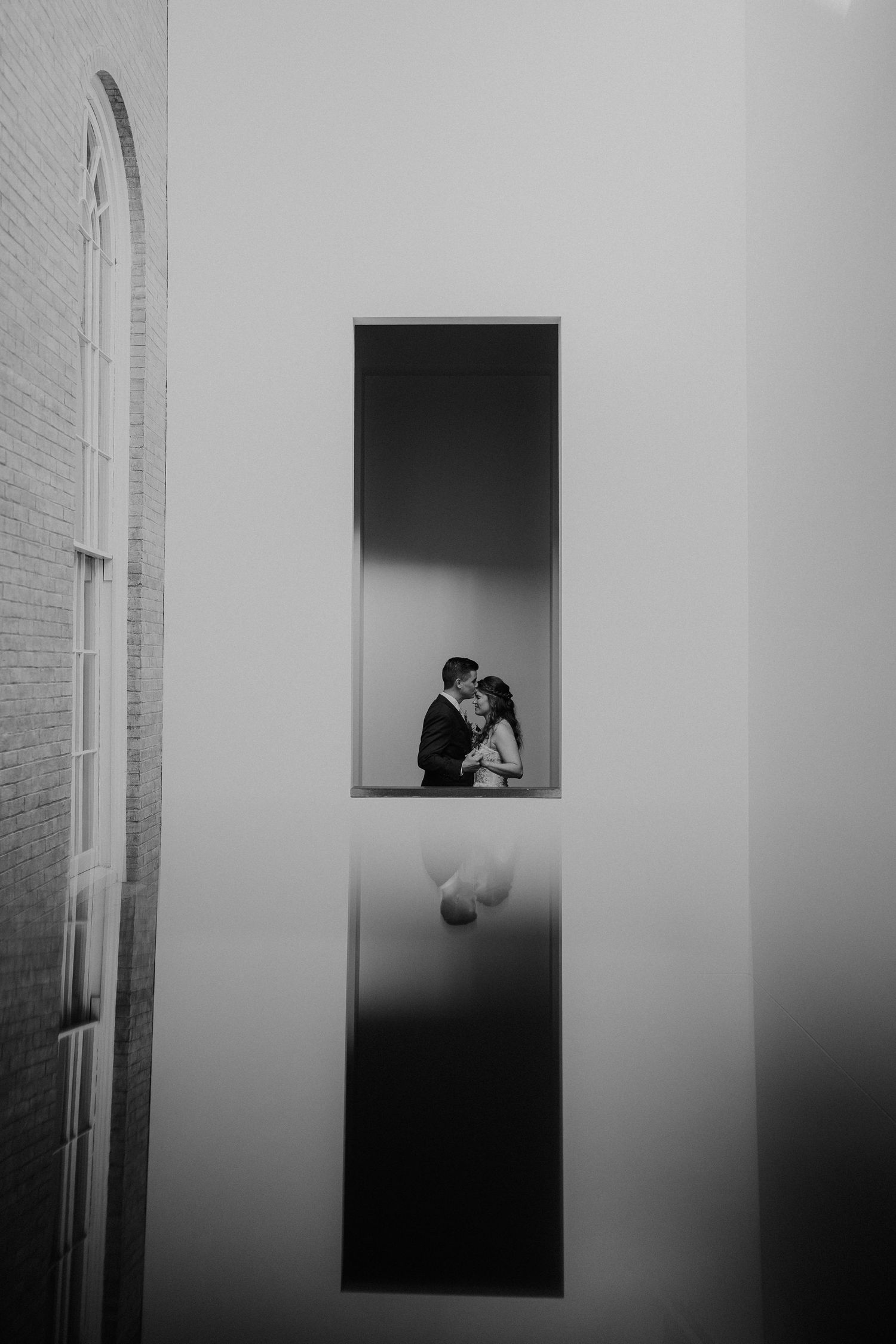 Minimalist black and white architectural wedding photos framed through window openings.