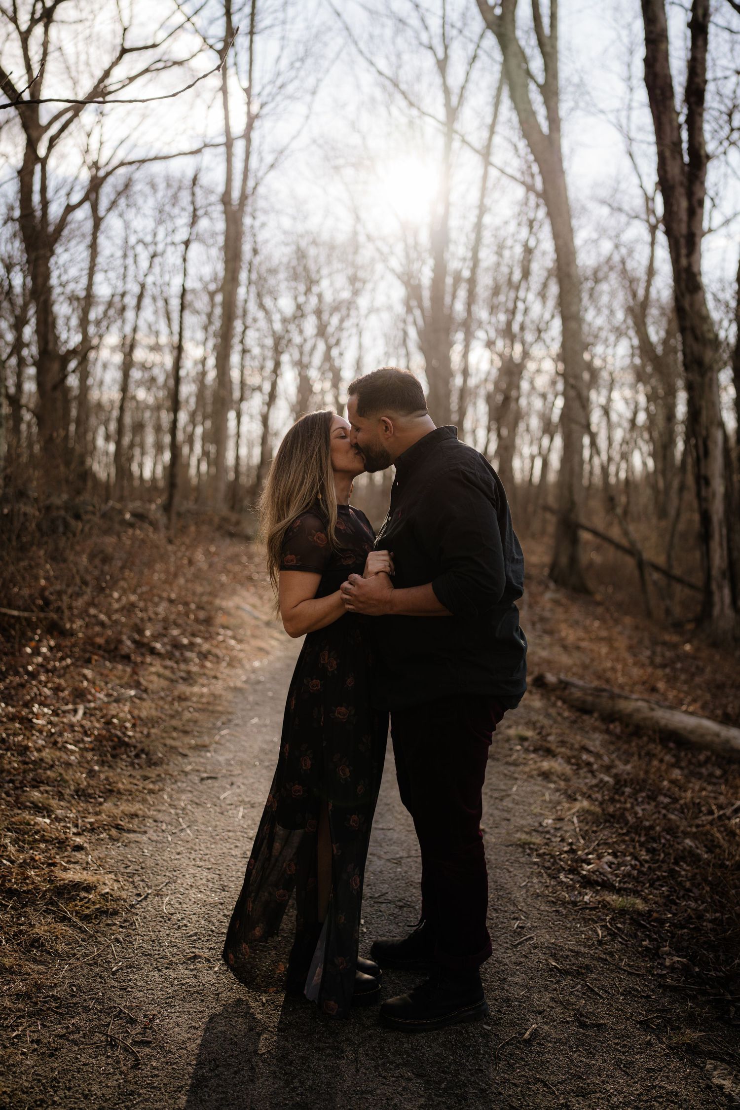 A romantic forest photoshoot on a wooded trail during golden hour.