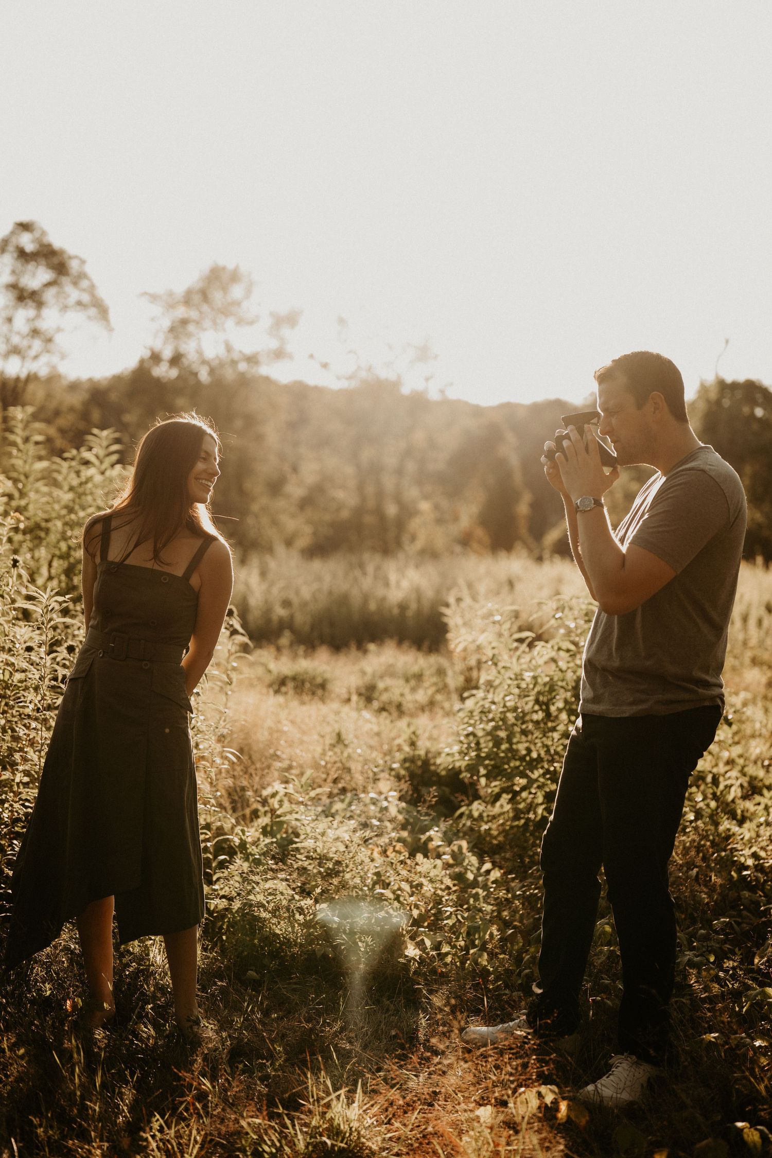 Romantic couple sharing tender moment in sunlit wildflower field.