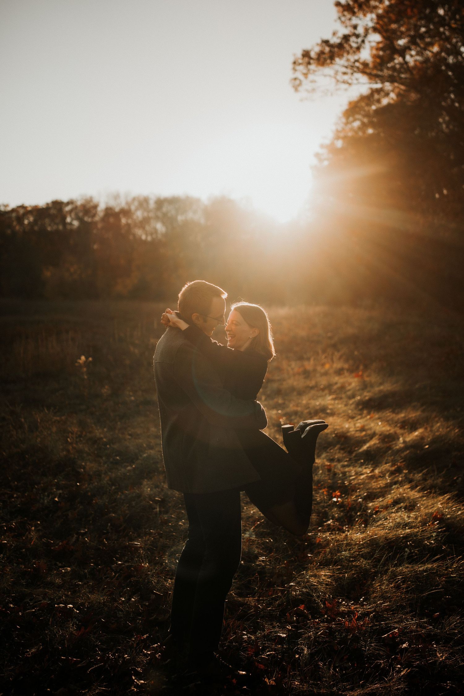 Silhouettes of couple against golden sunset in natural outdoor setting.