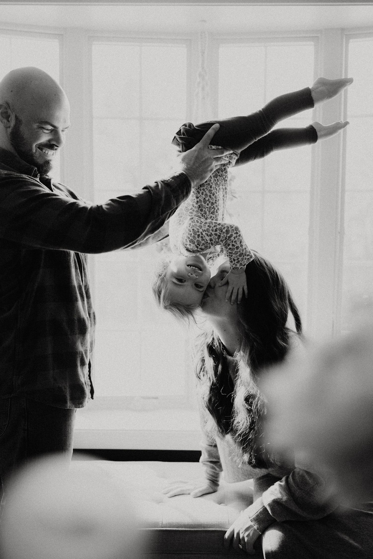 Playful black and white sequence showing movement and interaction by a bright window.