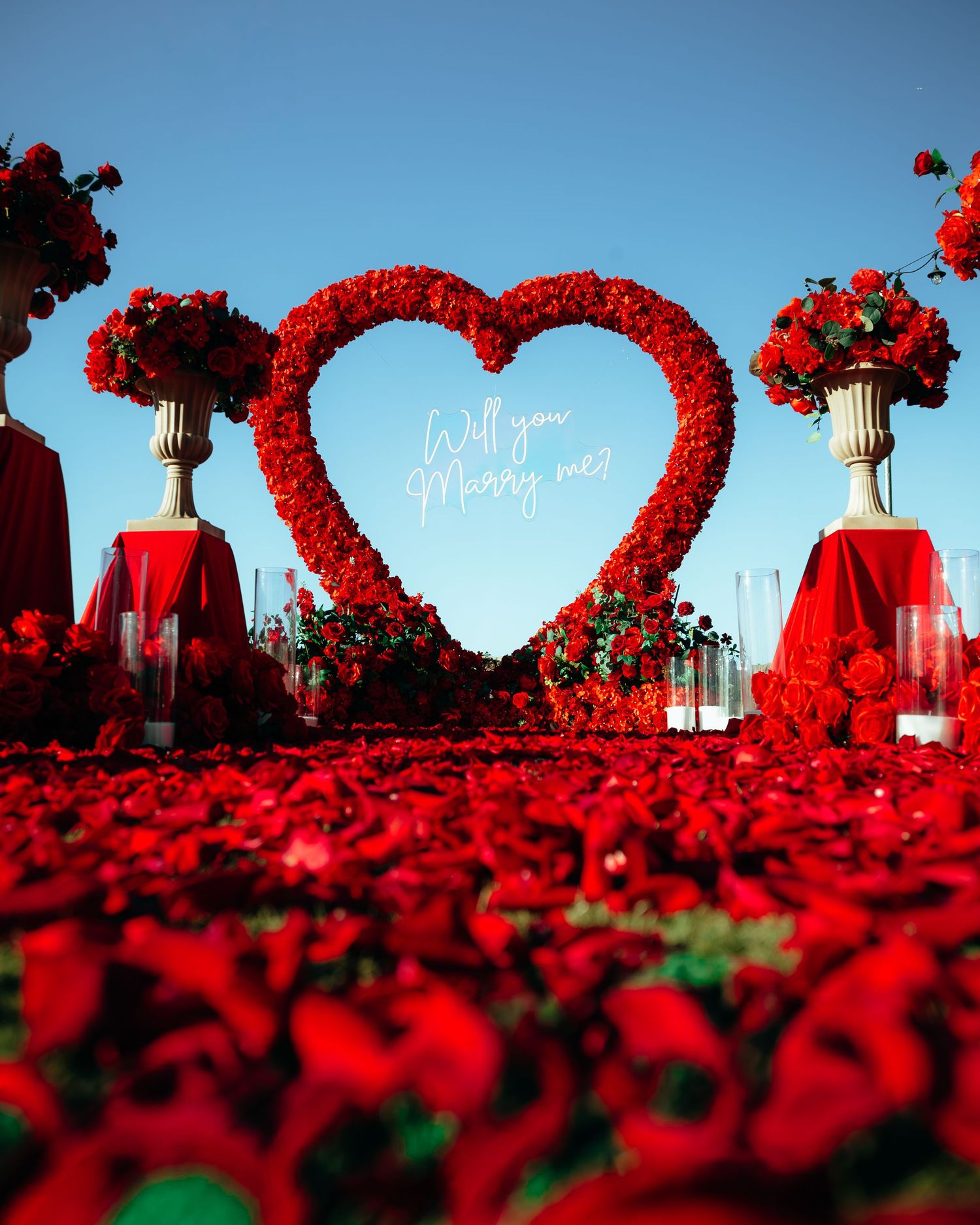 Romantic proposal setup with red rose heart arch and 