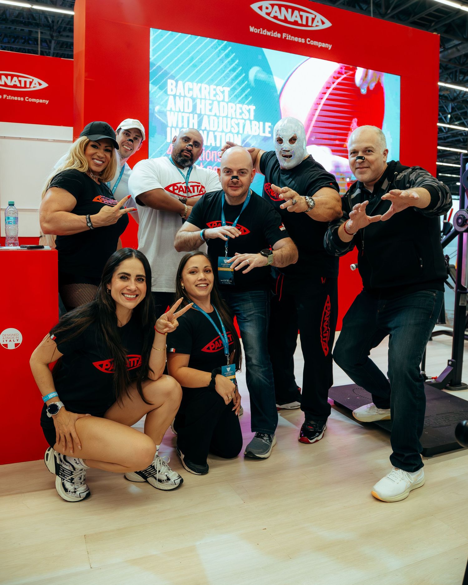 Team photo at a Panatta fitness expo booth with staff and mascot posing together.