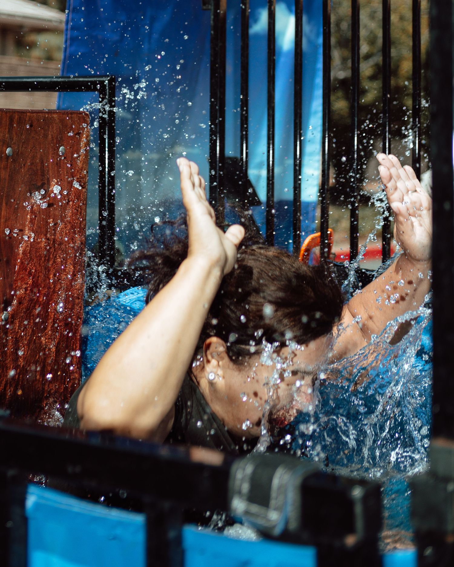 Person splashes into a dunk tank with water spraying dramatically around them.