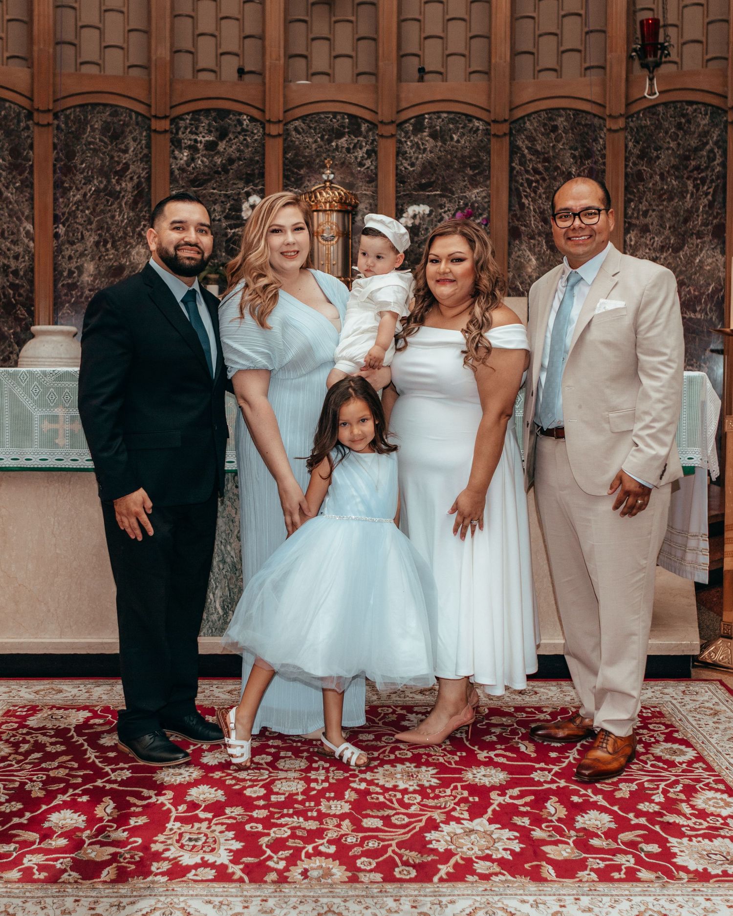 Family of six posing in church wearing blue and white formal attire.