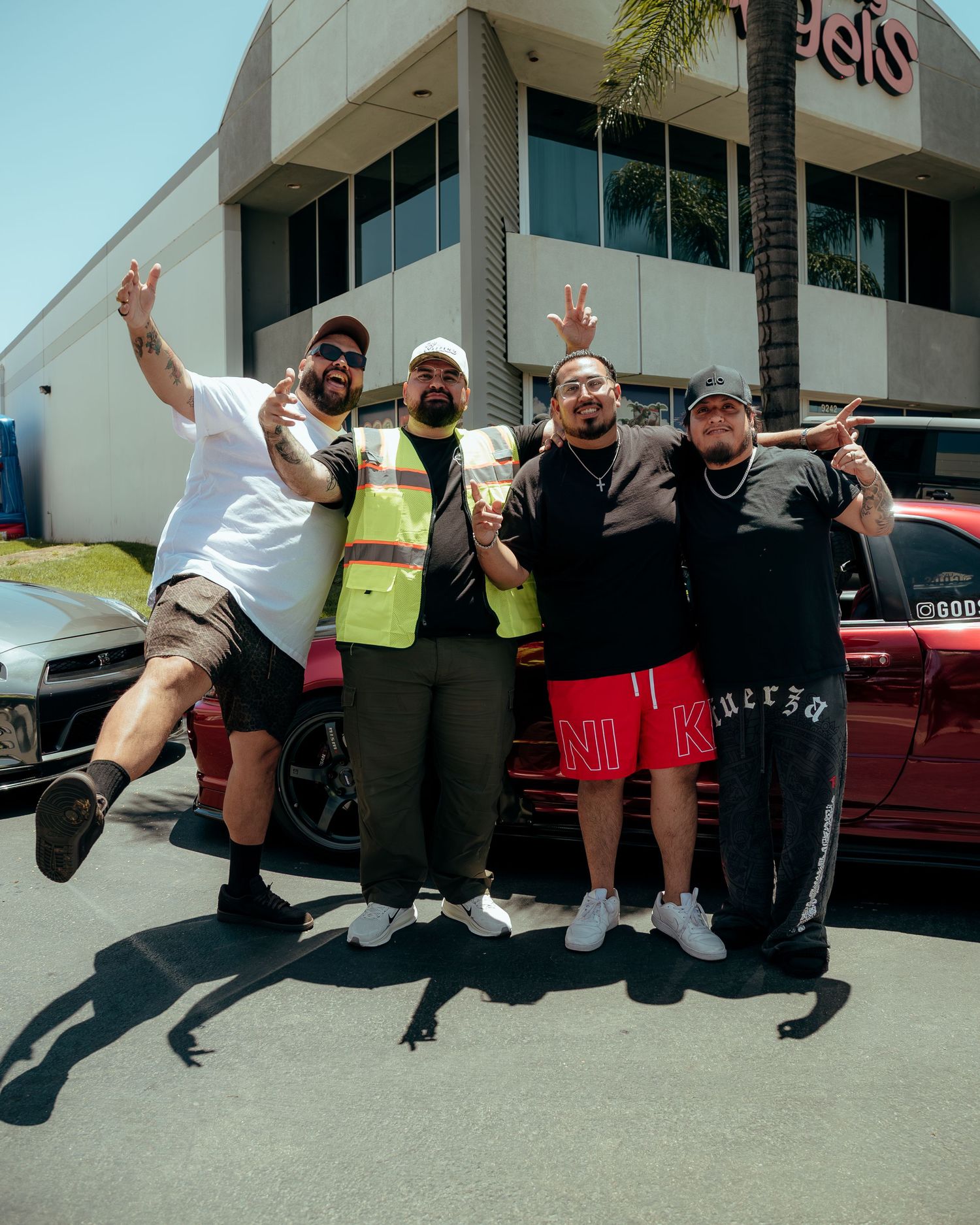 Four friends smiling and posing together in a sunny parking lot near a Target store.