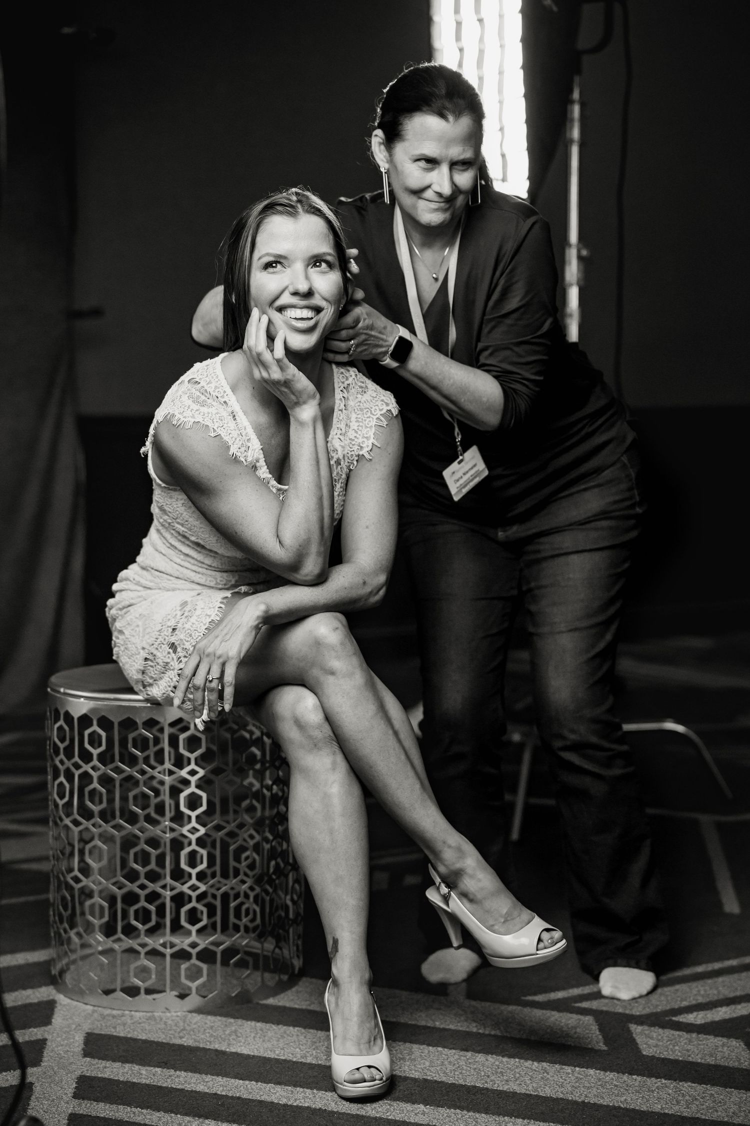 Black and white behind-the-scenes moment during professional photography preparation.