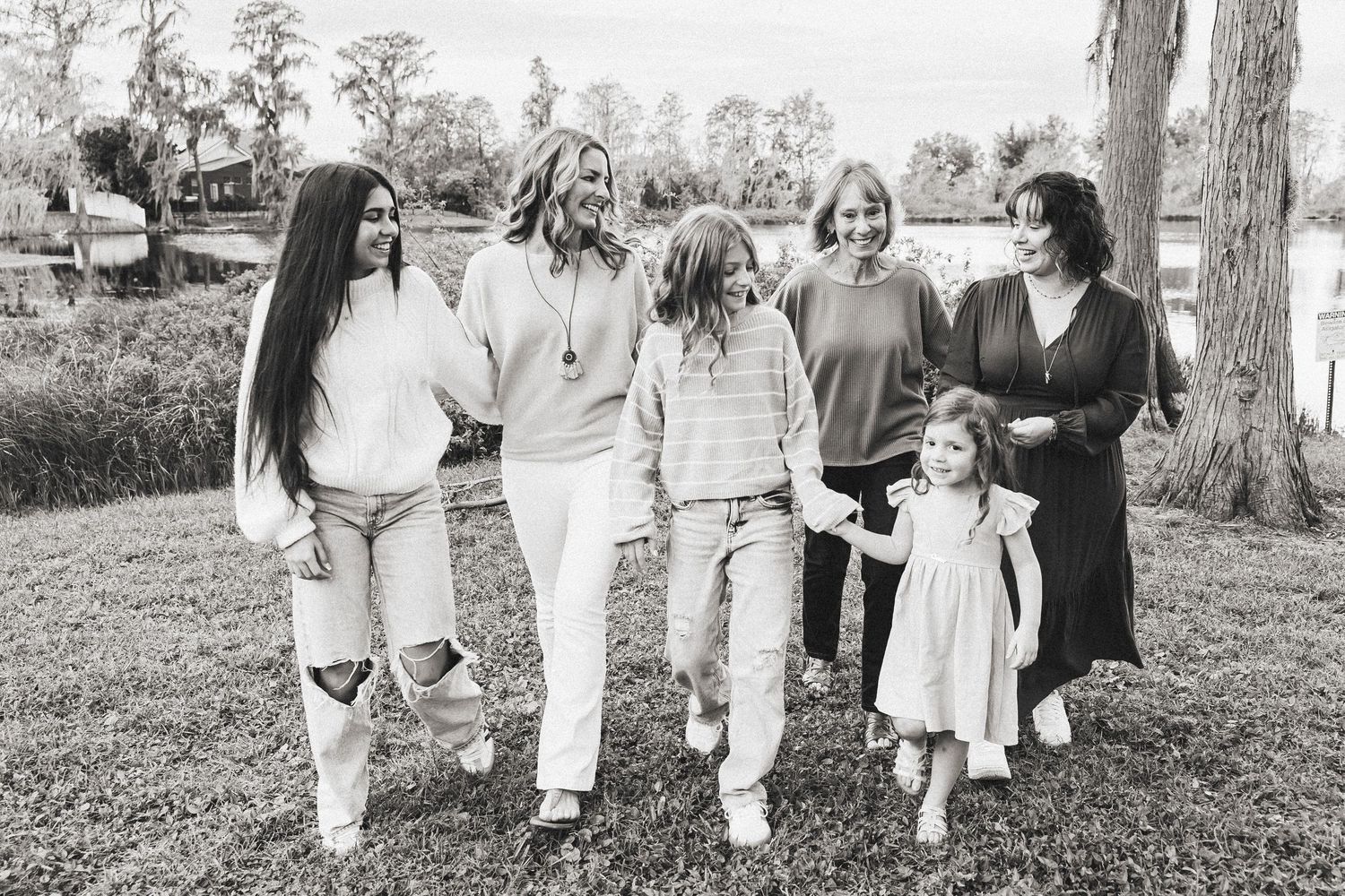 Black and white photo of multigenerational women and girls walking together outdoors.