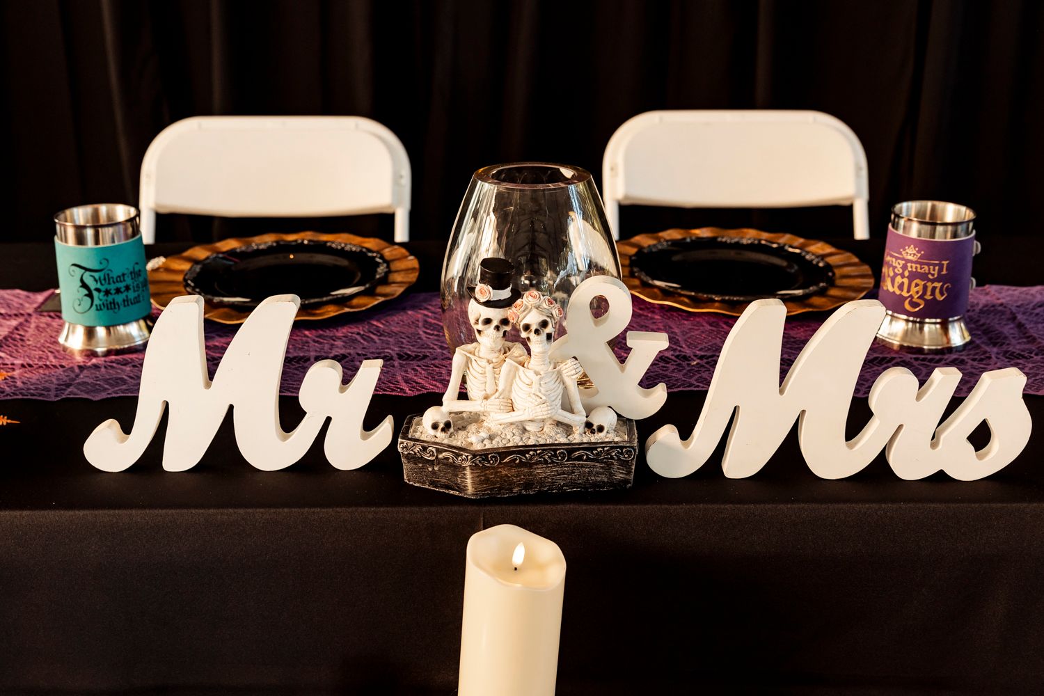 Reception table decorated with Mr & Mrs signs and romantic candlelight setting.
