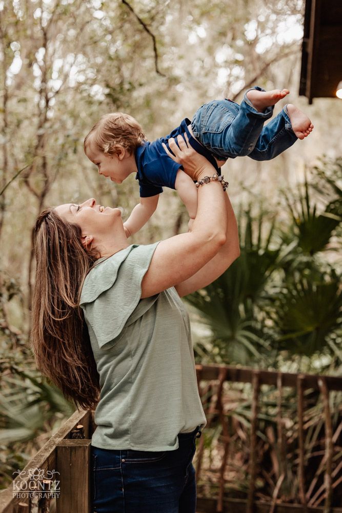 A joyful moment between parent and child playing outdoors near a wooden structure.