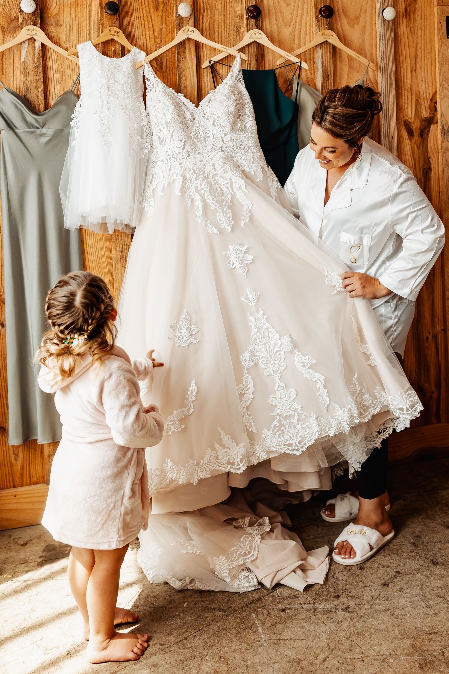 A beautiful white lace wedding dress being admired before the ceremony.