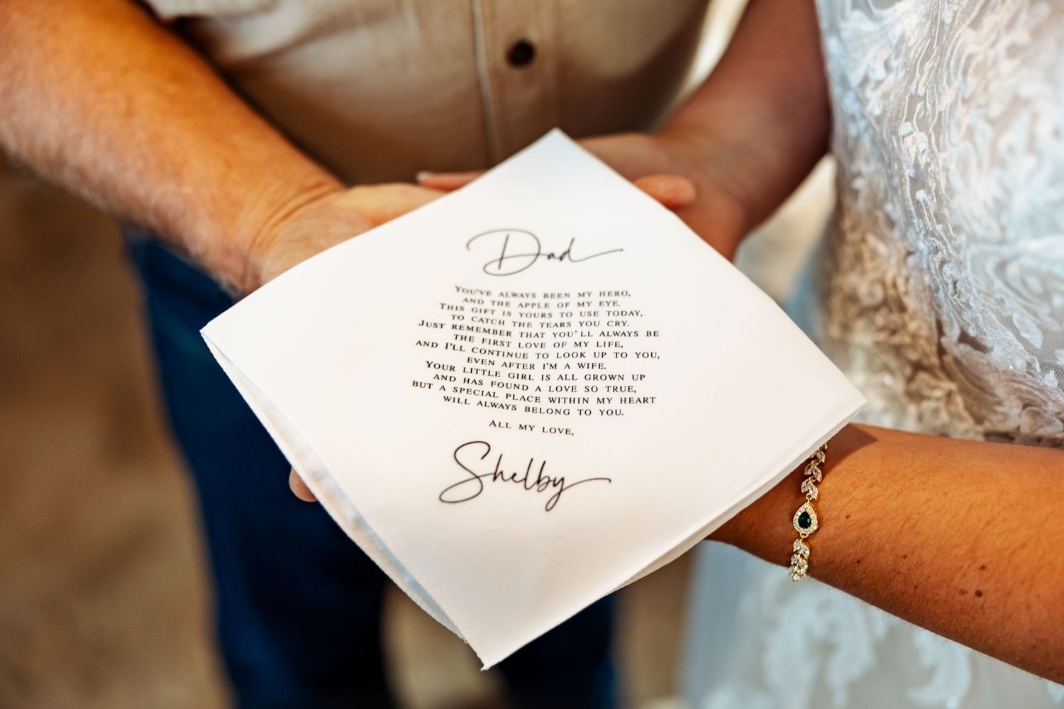 A handwritten wedding note being held between two people, showing personal vows or message.
