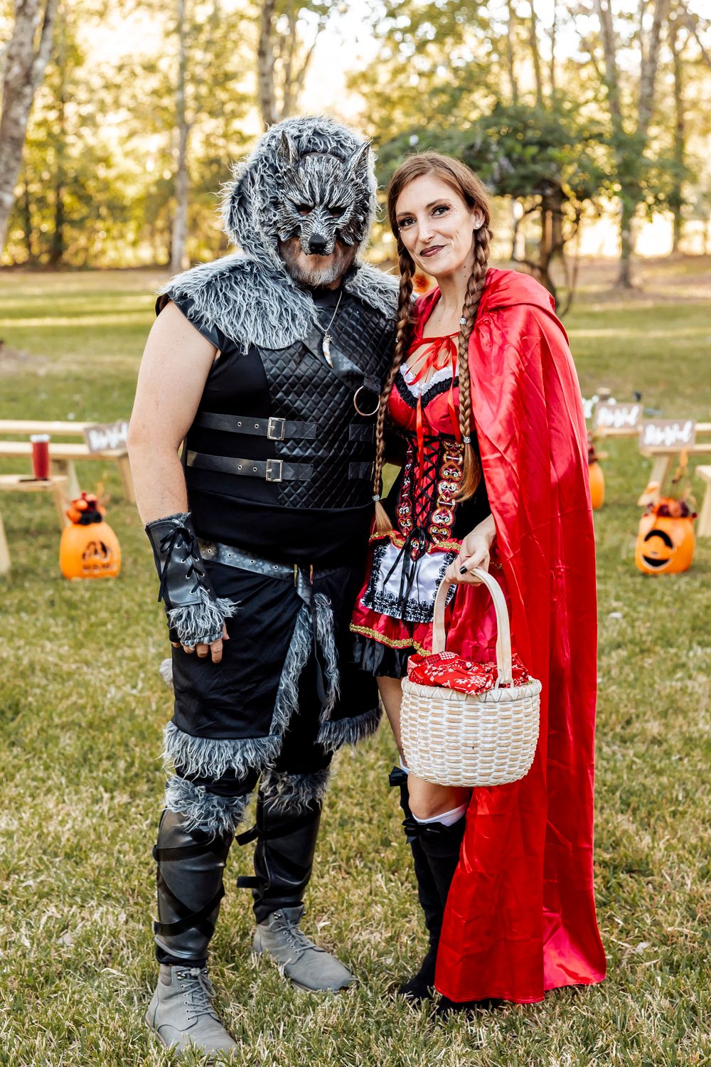 Halloween wedding guests dressed as Big Bad Wolf and Little Red Riding Hood pose in outdoor venue.