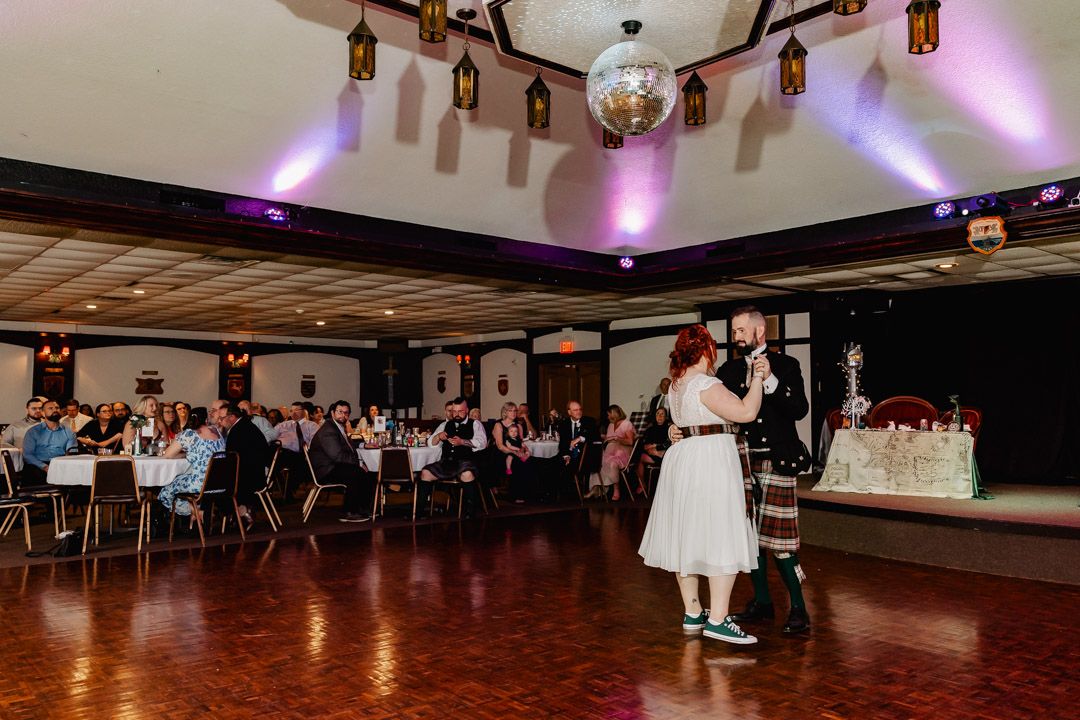Dance floor with purple lighting and disco ball in ballroom setting.