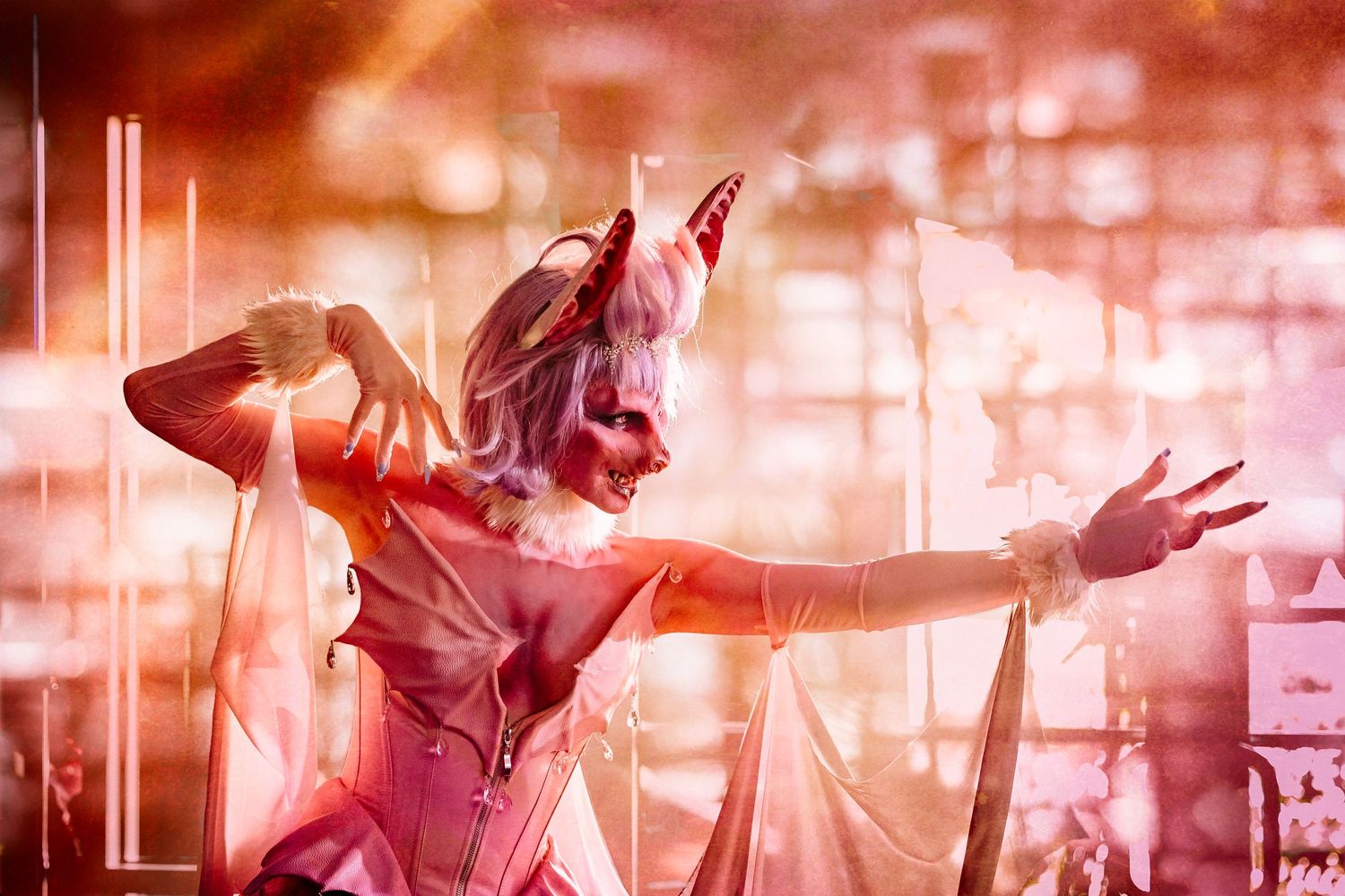 Theatrical performance with dramatic lighting shows costumed figure with outstretched arms on stage.