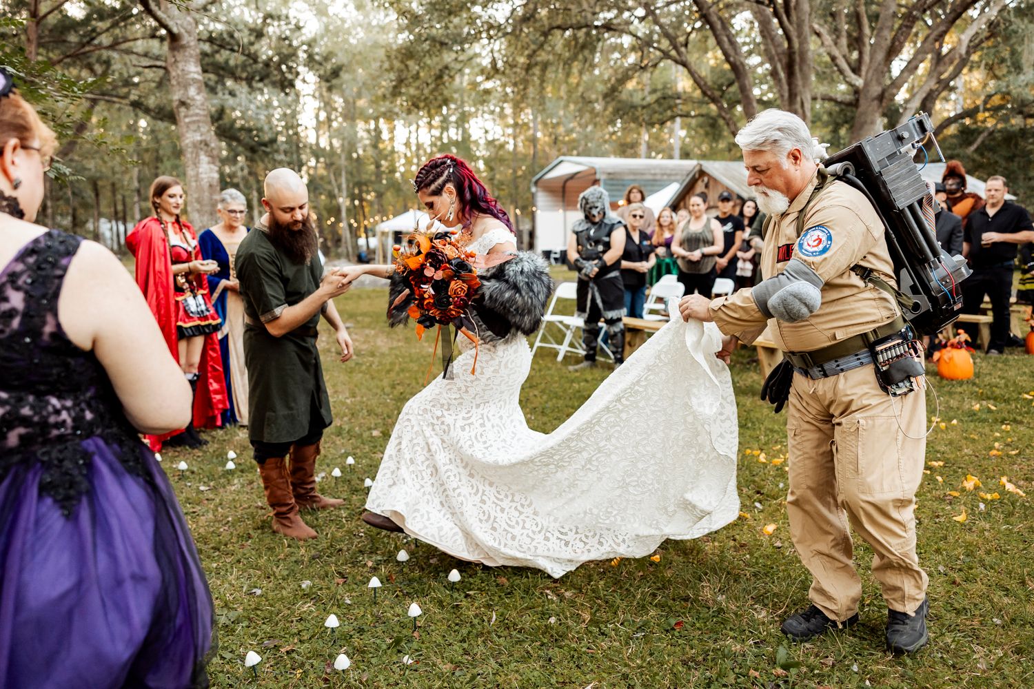 A festive outdoor wedding ceremony with guests gathered around in fall attire.