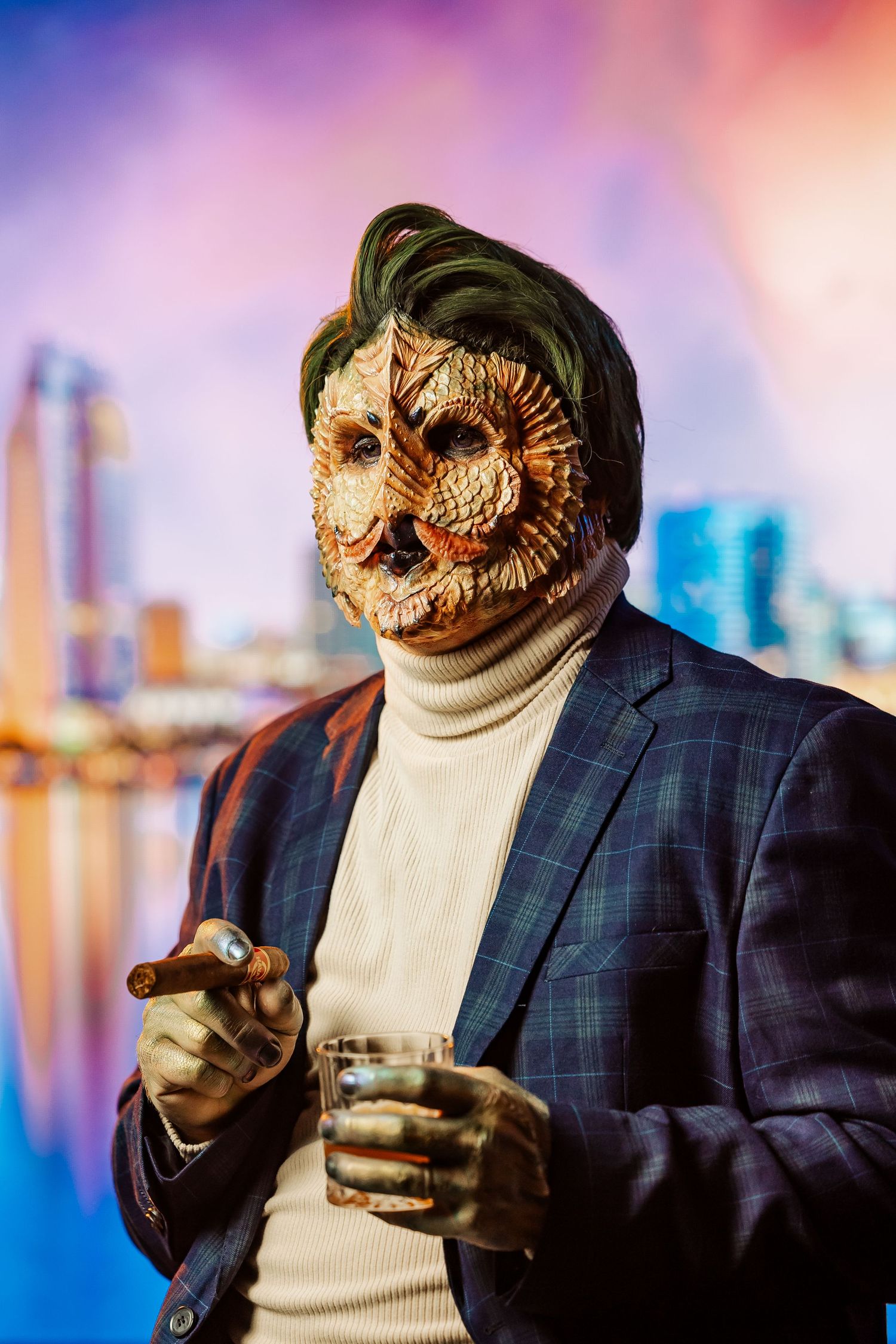 Man in plaid blazer wearing detailed owl creature mask holding cigar and drink against colorful city skyline.