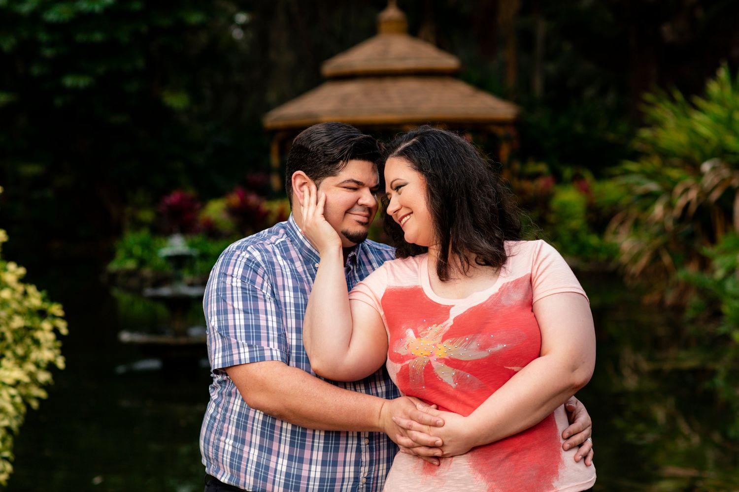 Couple sharing joyful moment in tropical garden setting.