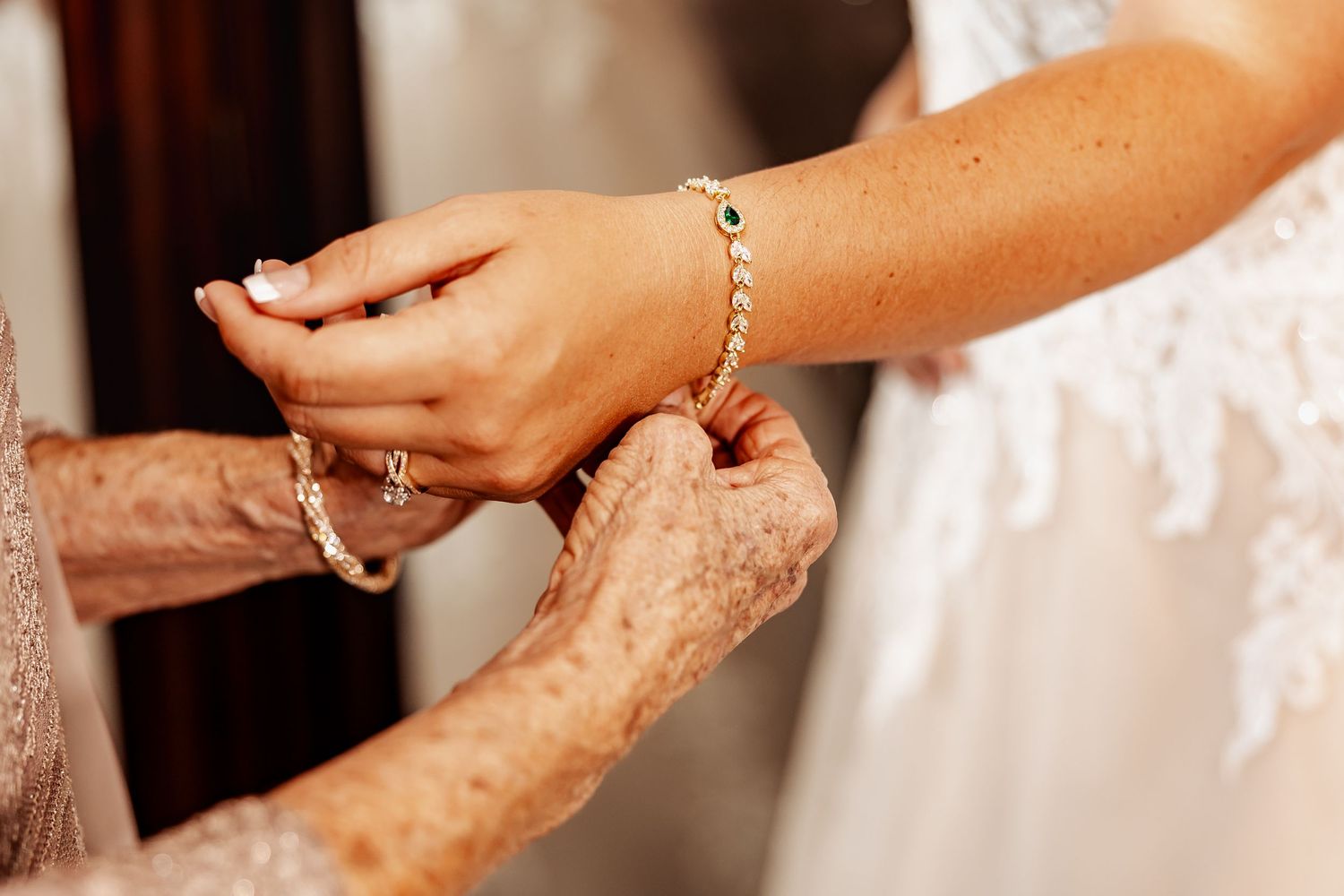 Close-up of hands adjusting bracelet during wedding preparations.