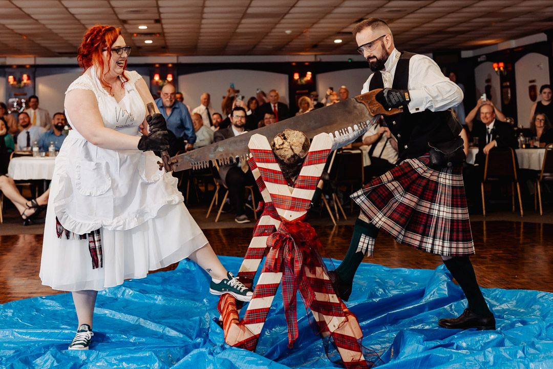 A playful sword fighting scene on a blue mat with Scottish wedding attire.