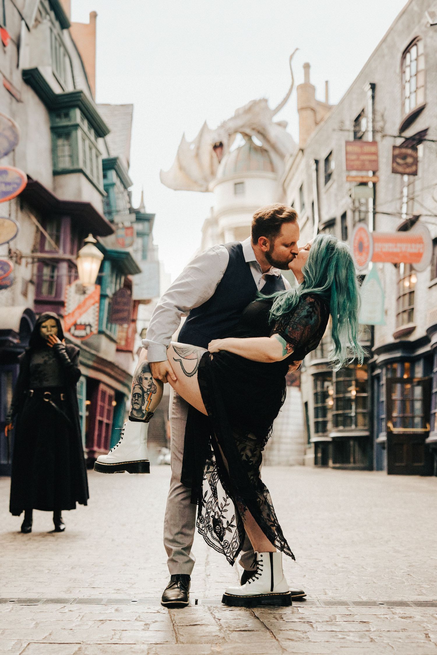Couple sharing intimate dance pose in themed alley with fantasy architecture.