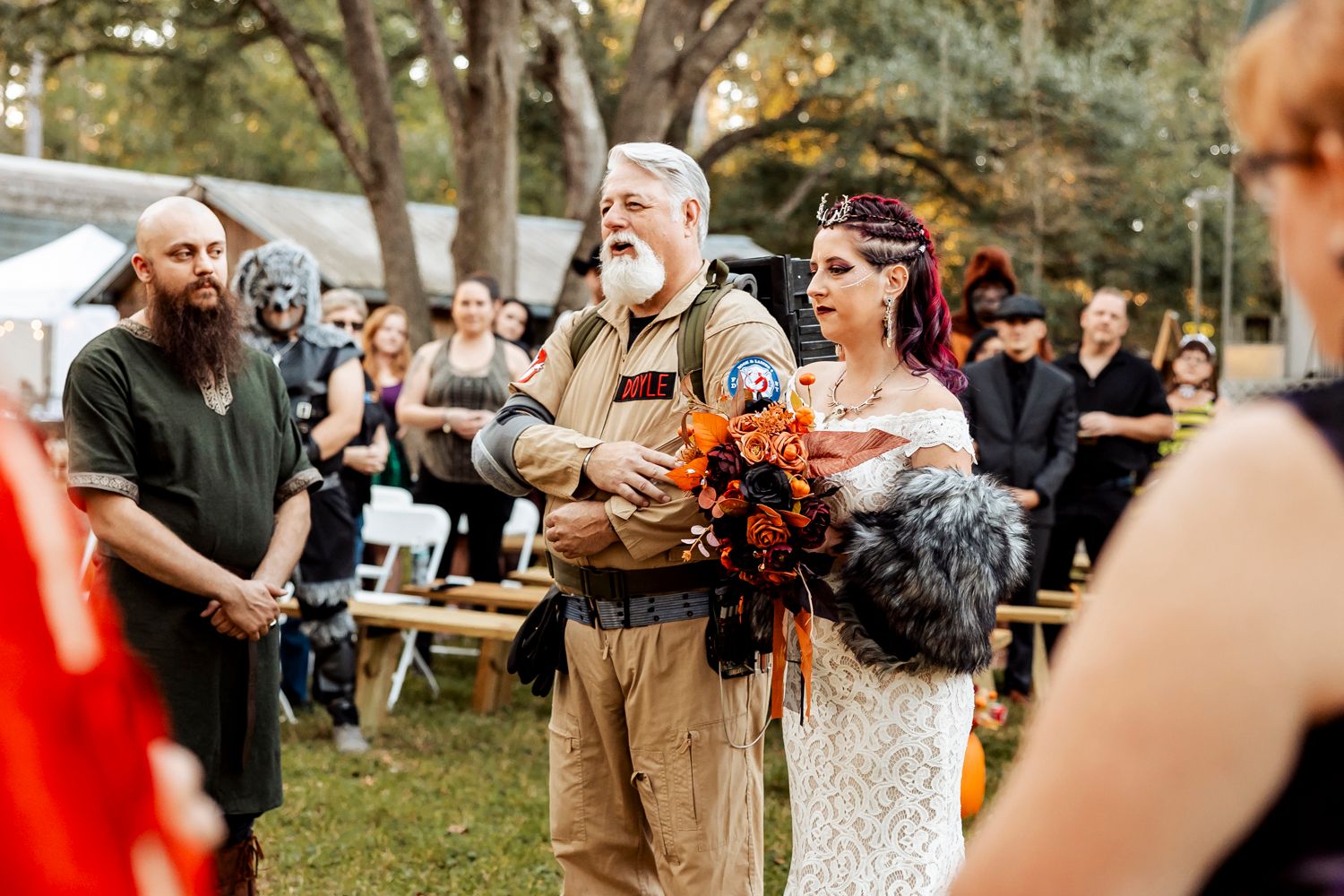 Bride with purple hair and father in Ghostbusters costume walk down aisle at themed wedding.