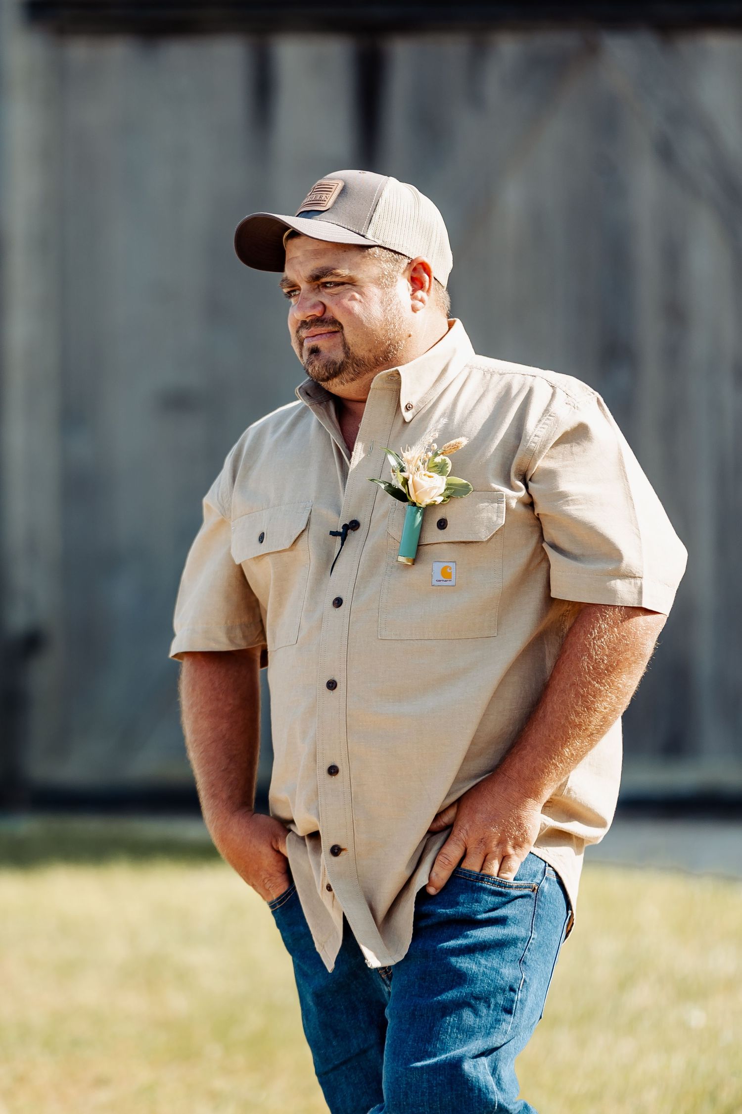 A wedding attendee in casual attire with a boutonniere.