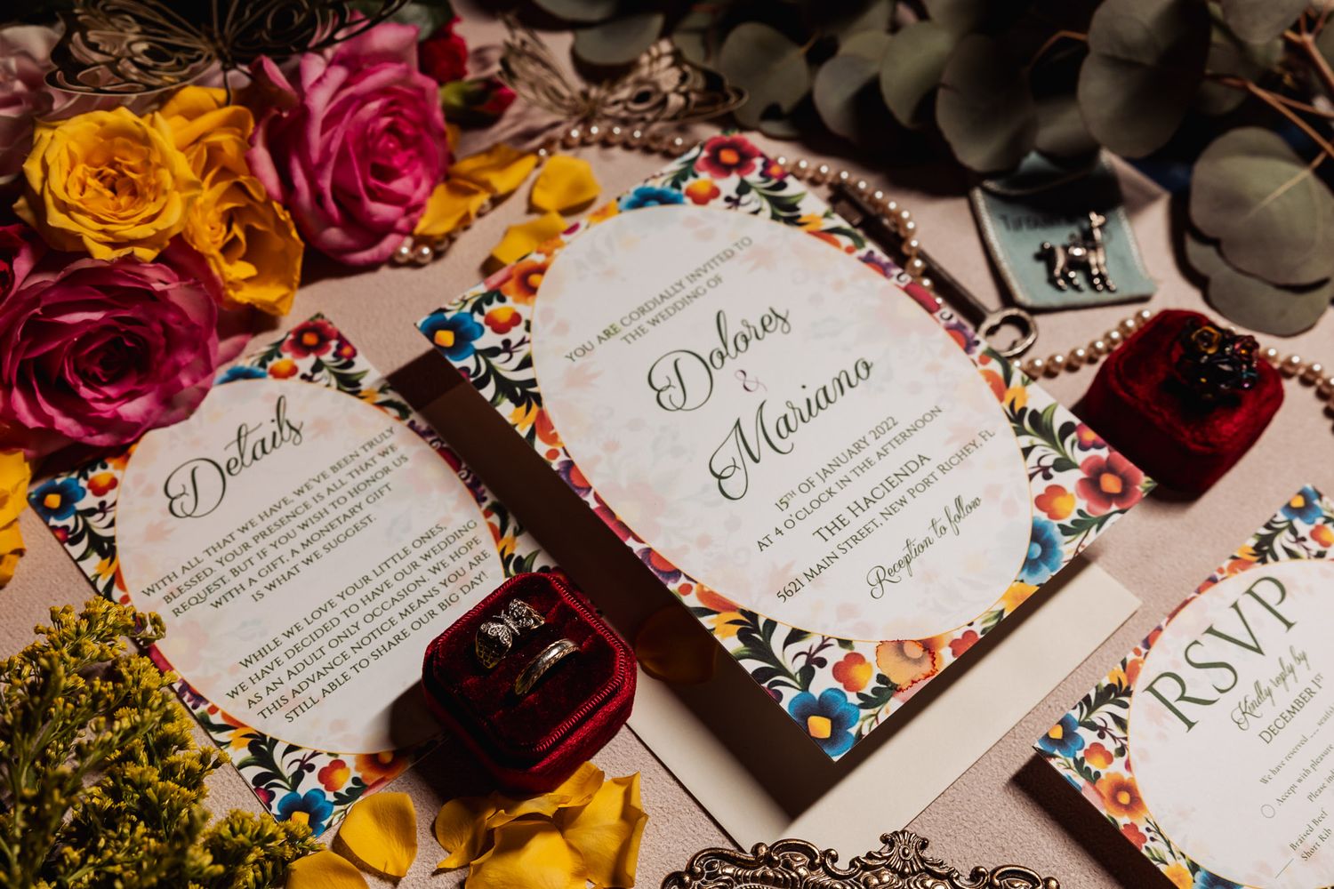 Elegant floral wedding invitation cards surrounded by colorful roses and decorative flowers.