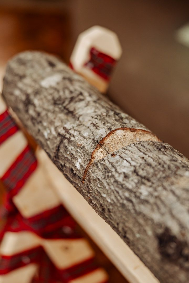 Close-up of rustic log with red plaid ribbon detail.