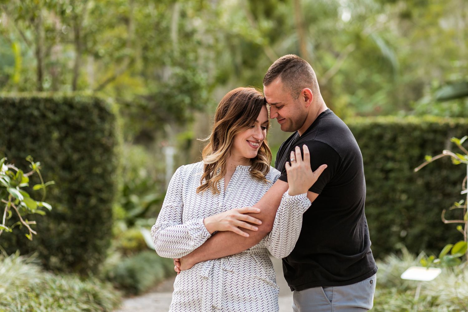 Intimate outdoor portrait of couple embracing in garden setting.