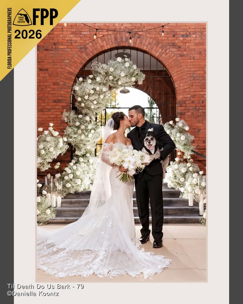 FPP 2026 awarded wedding photo of bride and groom with dog under white floral arch at brick church.