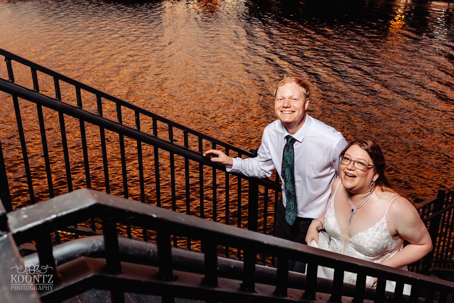 Joyful moment captured on waterfront stairs during golden hour.