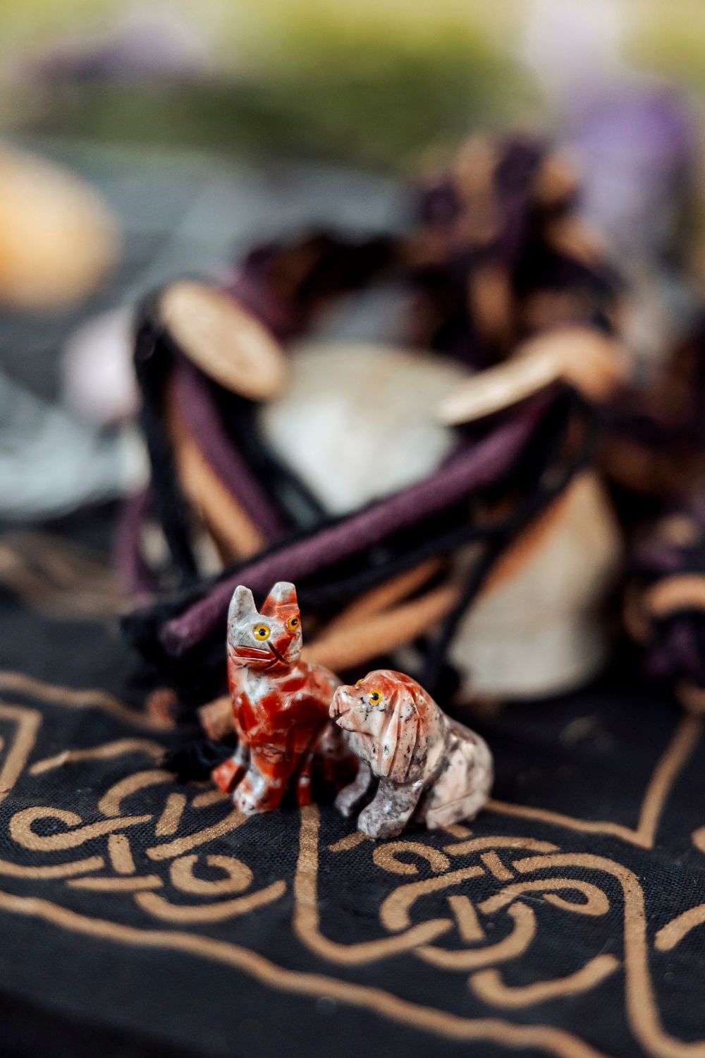 Small decorative figurines of a fox and wolf on an ornate patterned surface.