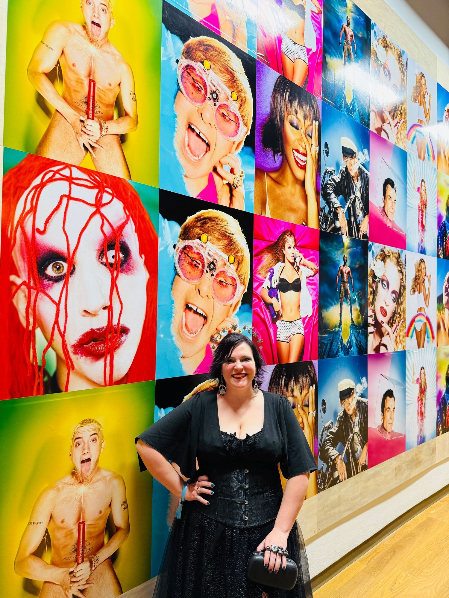 Colorful gallery wall display featuring vibrant pop art style portraits and photographs arranged in a grid pattern.