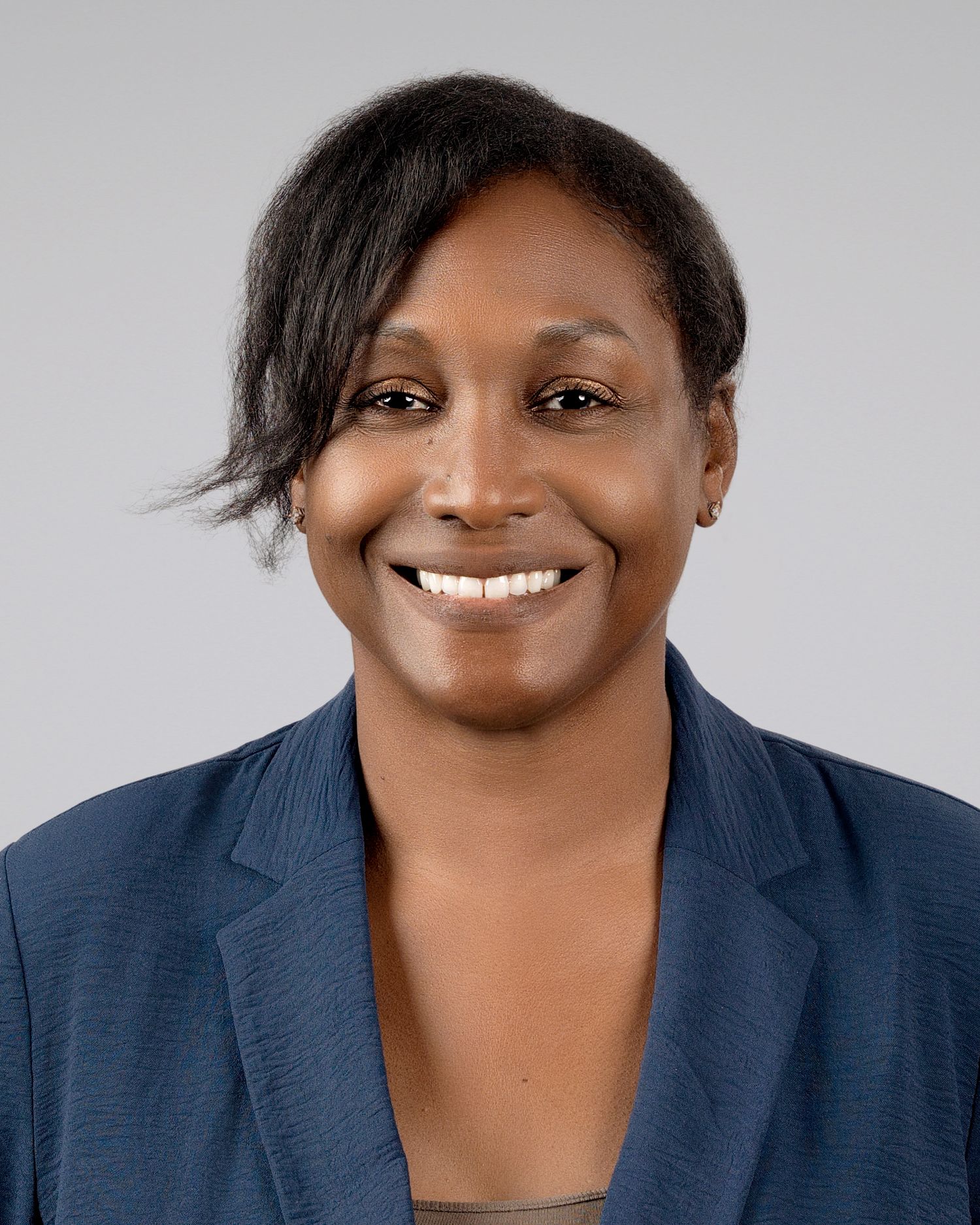 Professional headshot of a smiling Black woman wearing a navy blue blazer.