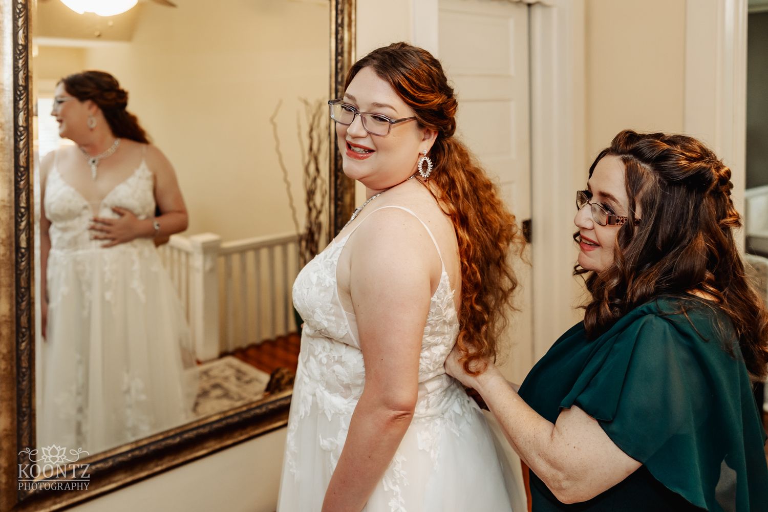 A bridal preparation scene with joyful laughter being shared while looking in a mirror.
