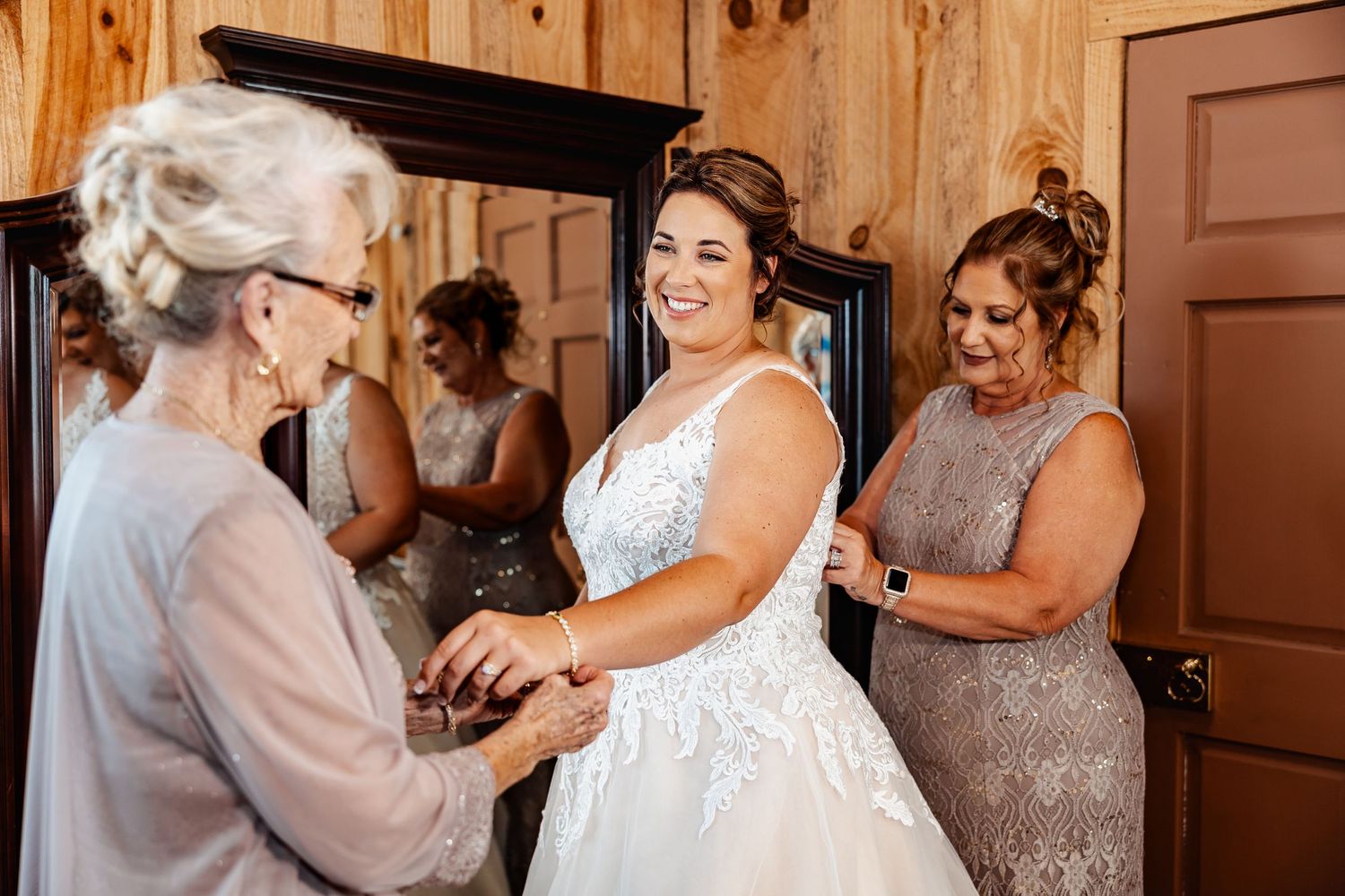 Intimate moment during wedding preparations in wooden paneled room.