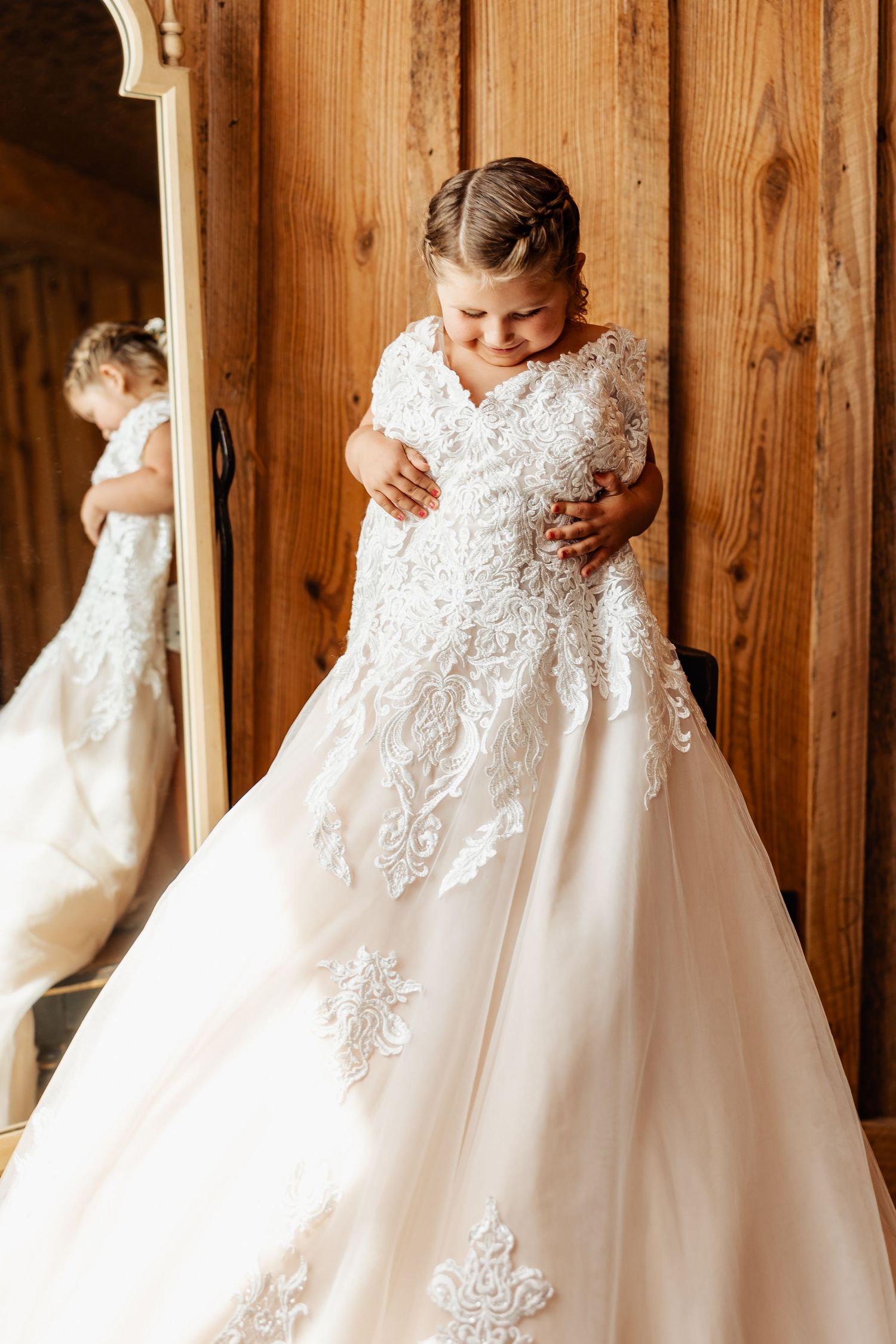 Beautiful lace wedding dress displayed in mirror reflection.