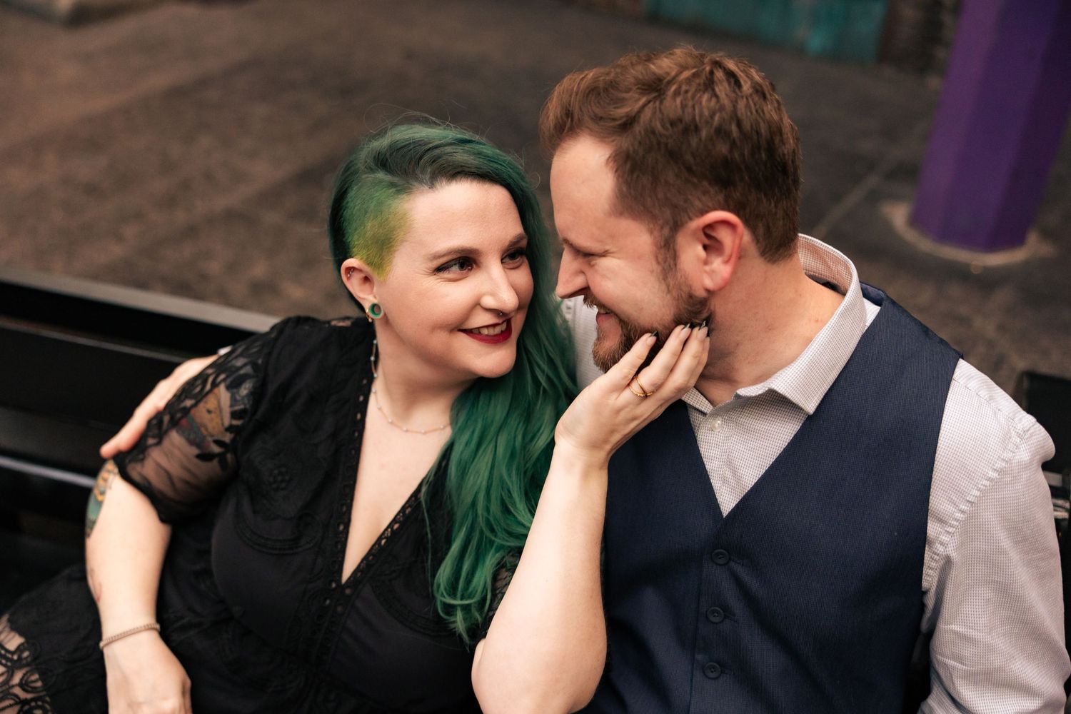 A couple sharing an intimate laughing moment outdoors.